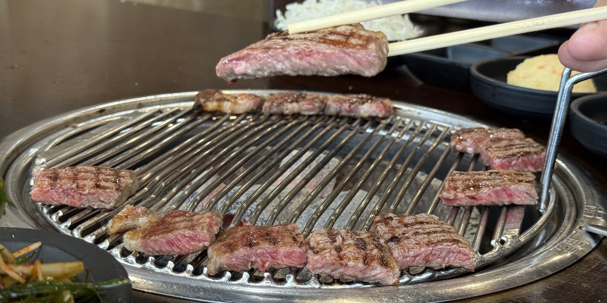 Beef being grilled over a Korean BBQ table grill
