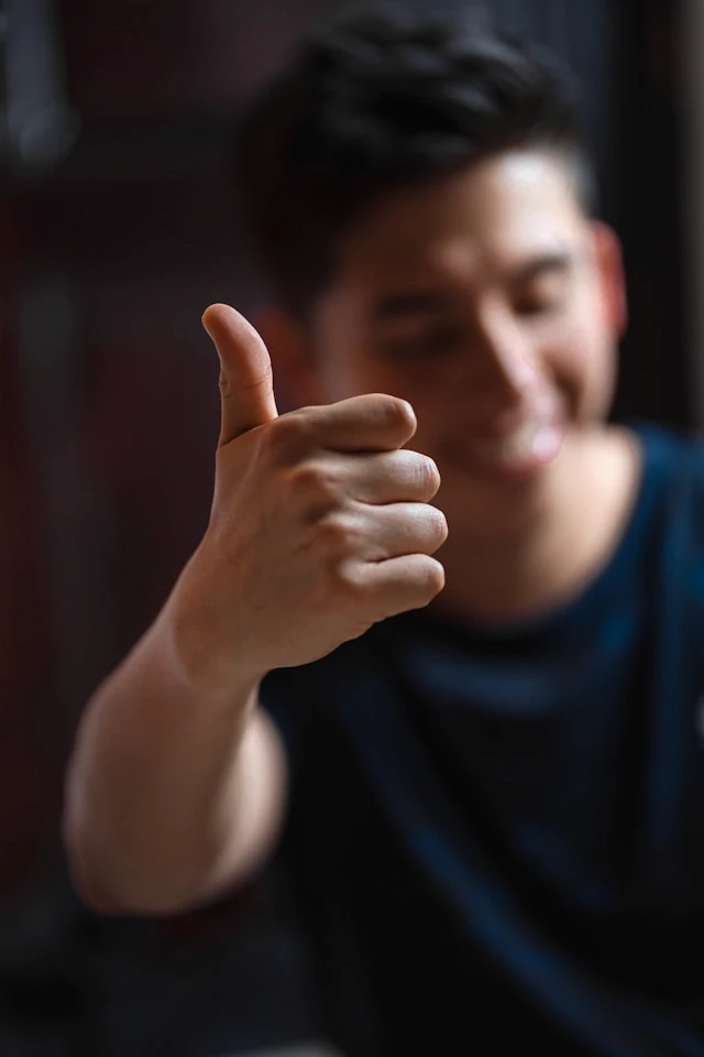 Close-up of a person giving a thumbs up gesture, representing early awareness and positive progress.