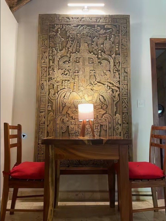 Comedor de Casa Maya con panel tallado en la pared