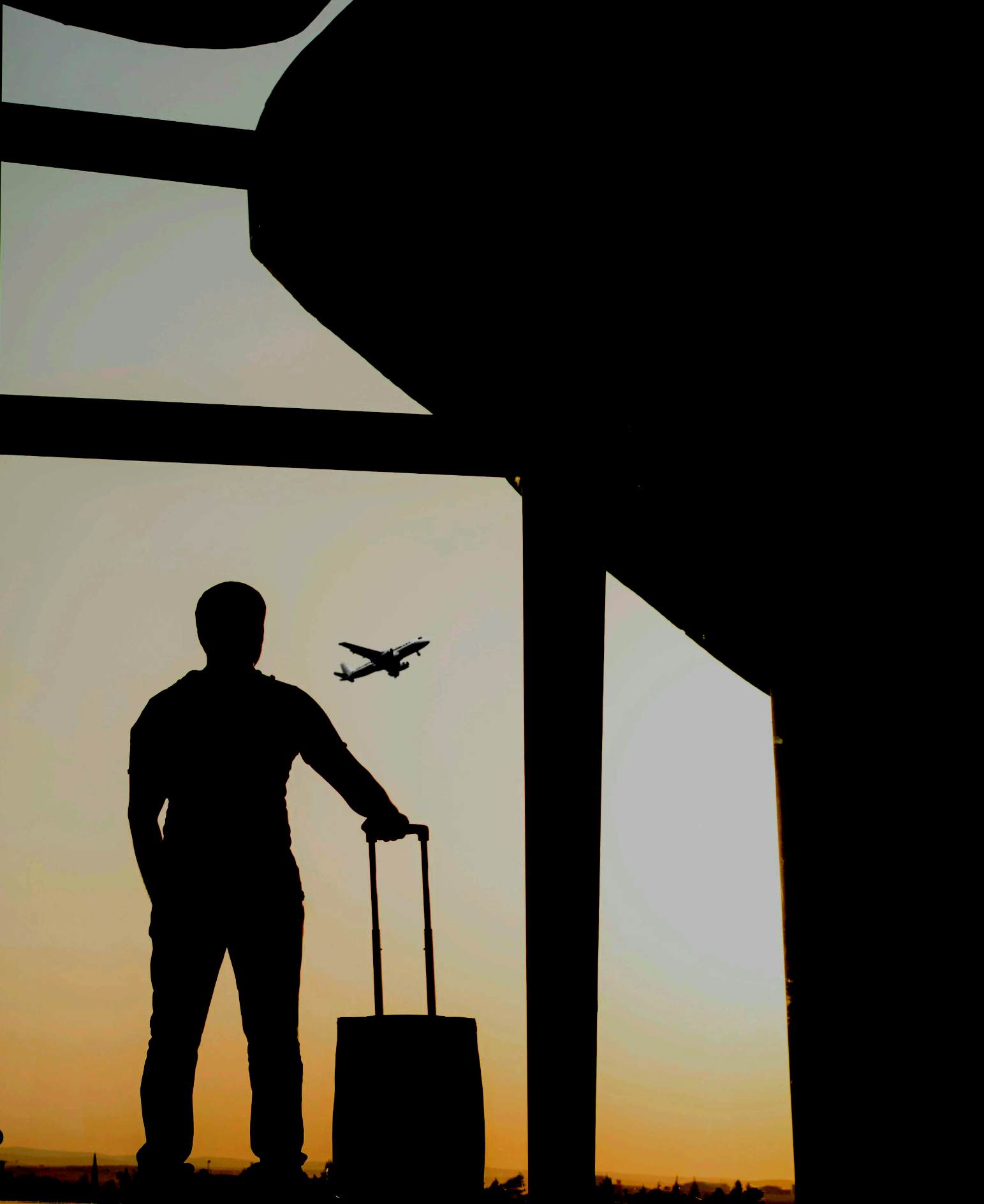 silhouette of man holding luggage inside airport