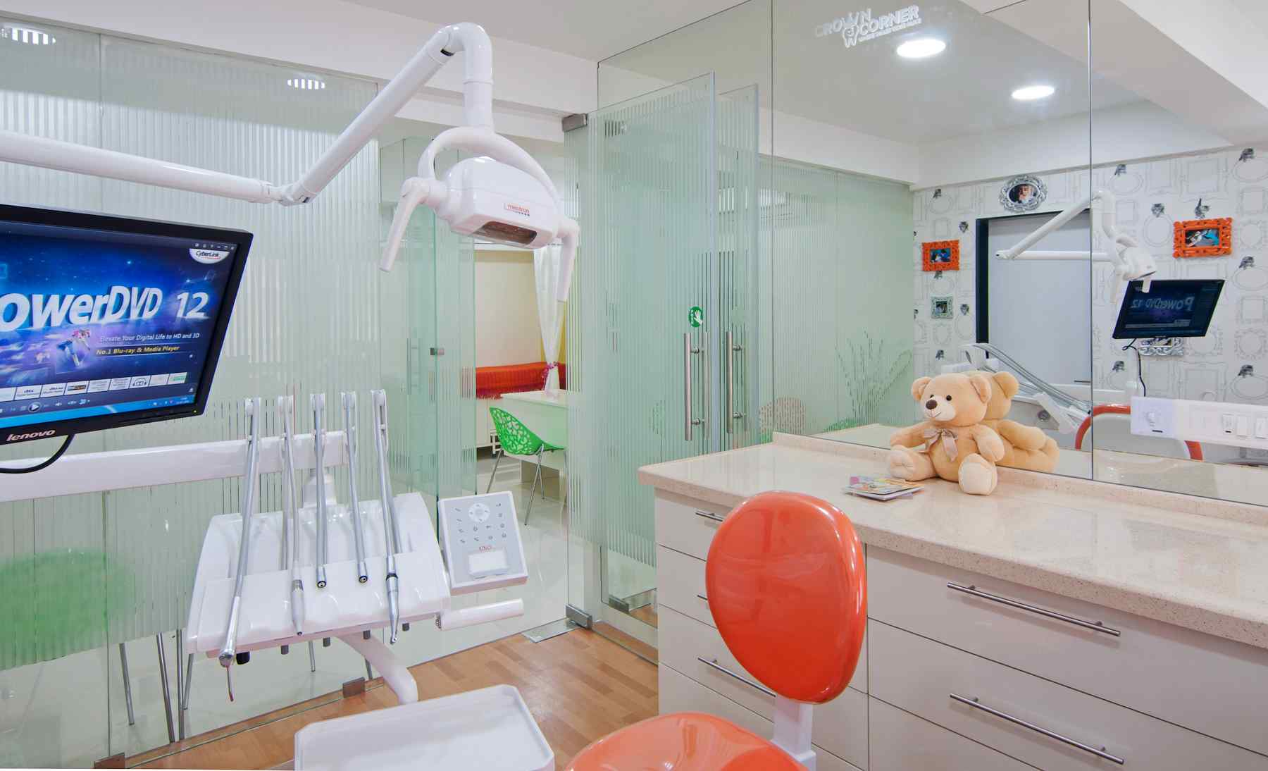 Nature-inspired preschool entrance with sculptural tree partitions and suspended green leaf ceiling panels.