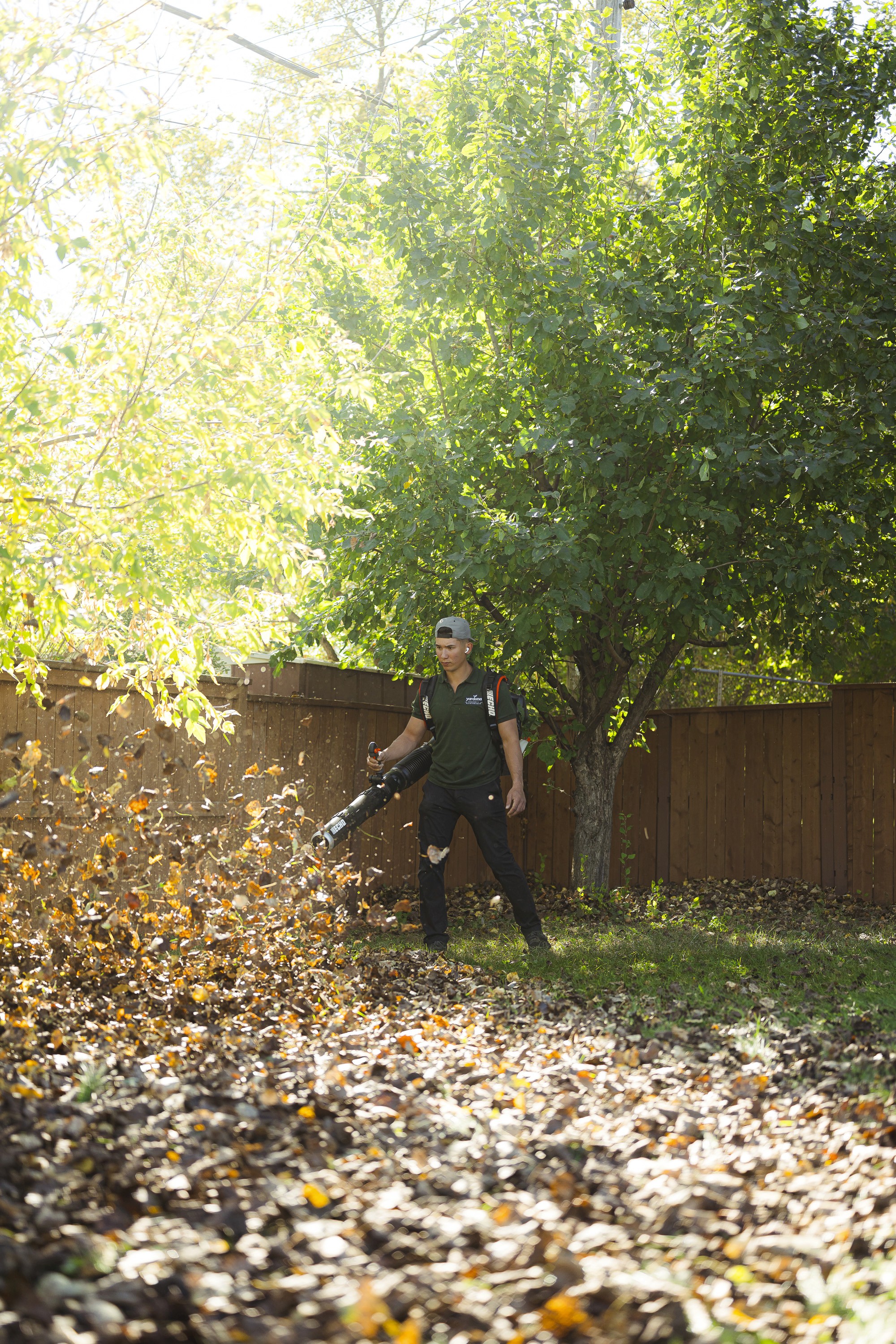 Worker using a leaf blower for fall cleanup, showcasing Yardona’s seasonal property services in Winnipeg.