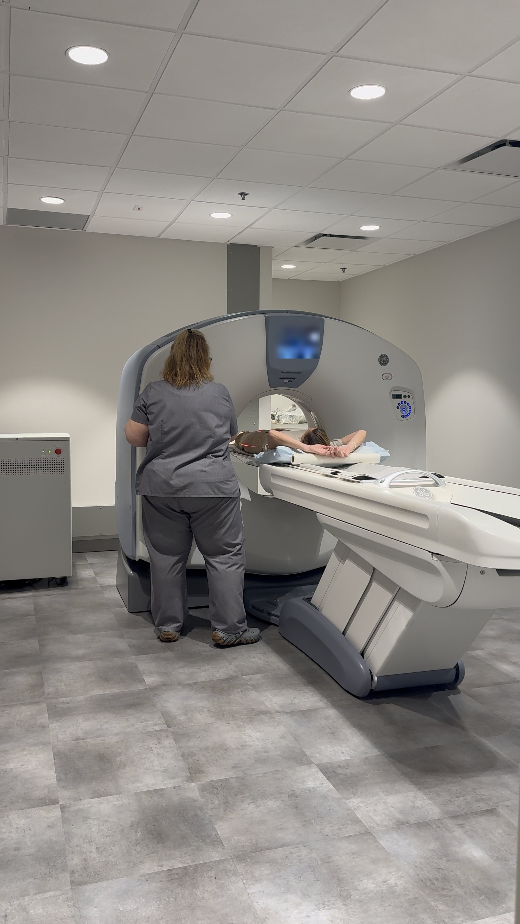 CT scanner suite with a technologist and patient