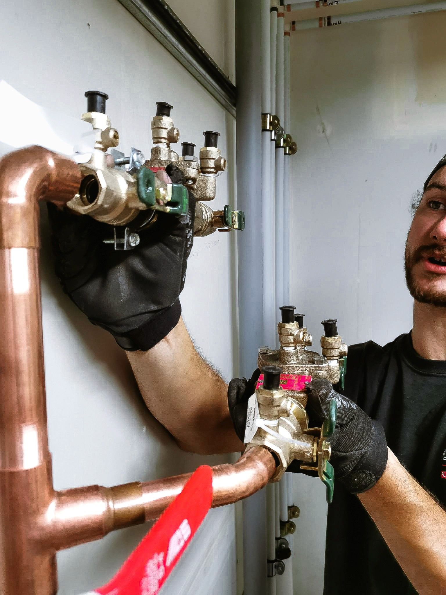Plumbing expert in Chilliwack, British Columbia, working on copper pipes and valves for HVAC systems.