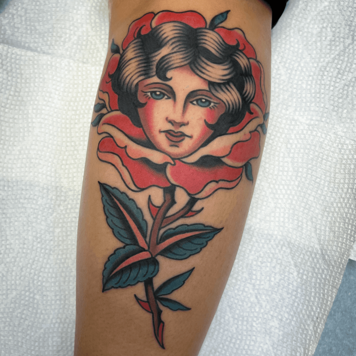 color tattoo of a girl head inside of a rose