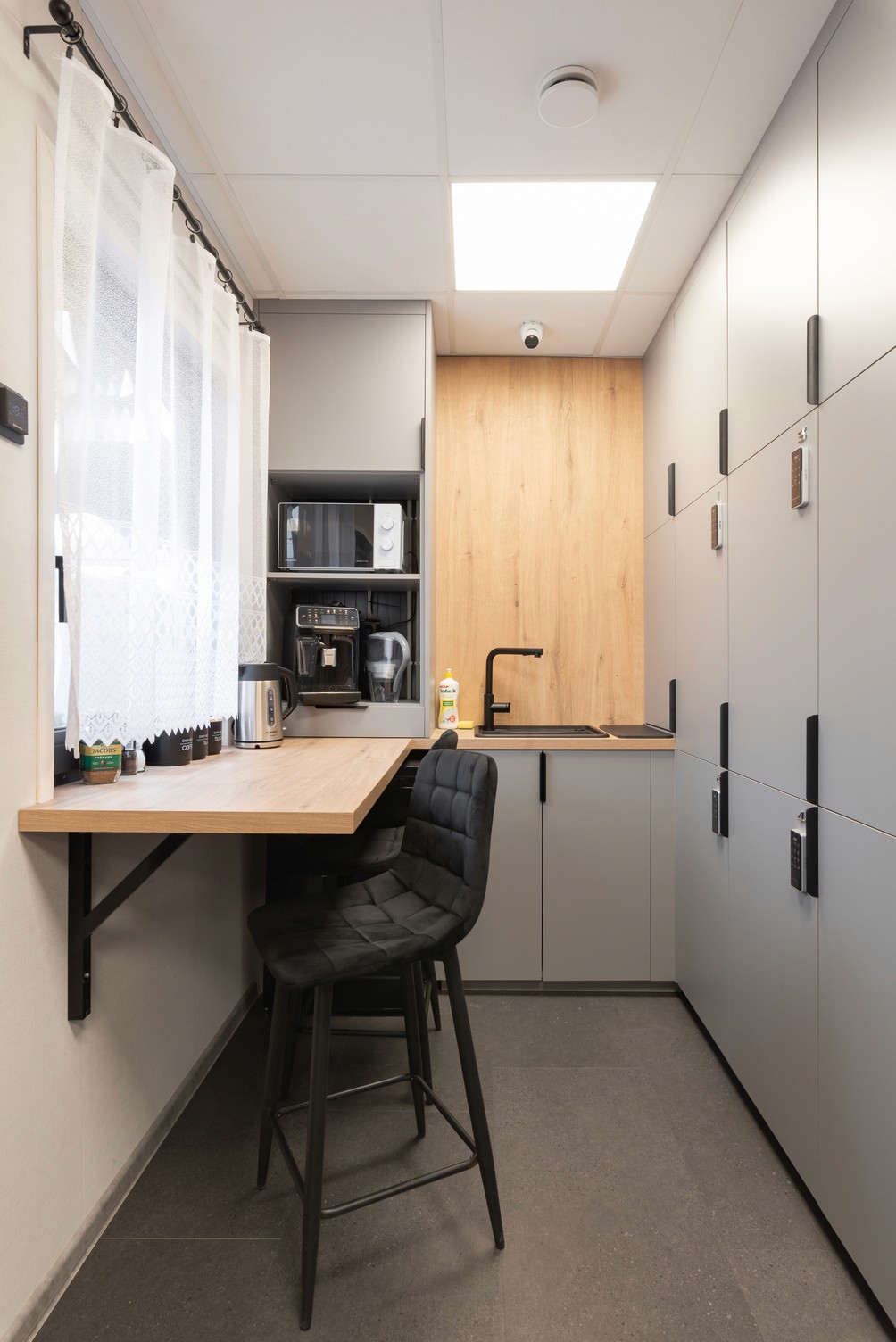 Modern capsule hotel room with individual sleeping pods. Wooden design, each with a bed, pillow, and privacy.