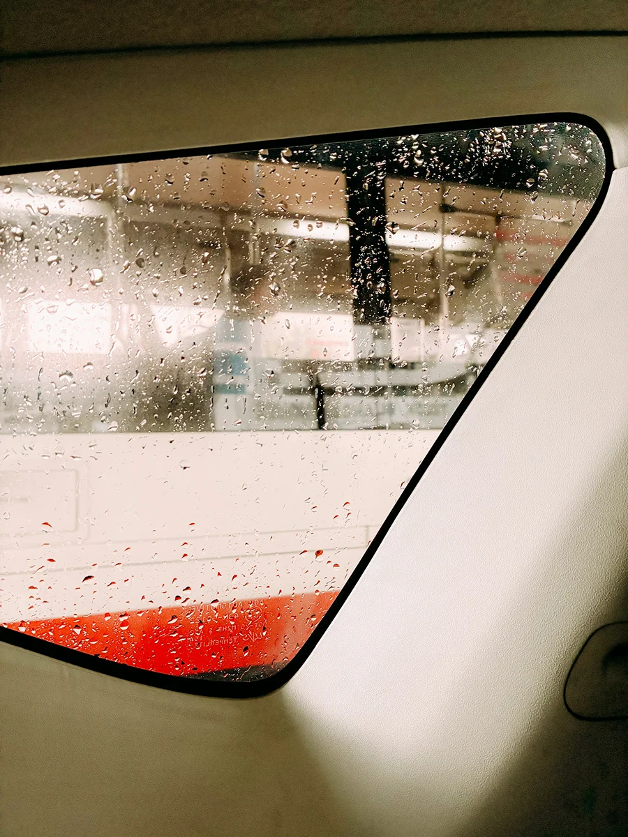 Water droplets on a car window after glass treatment and water spot removal service