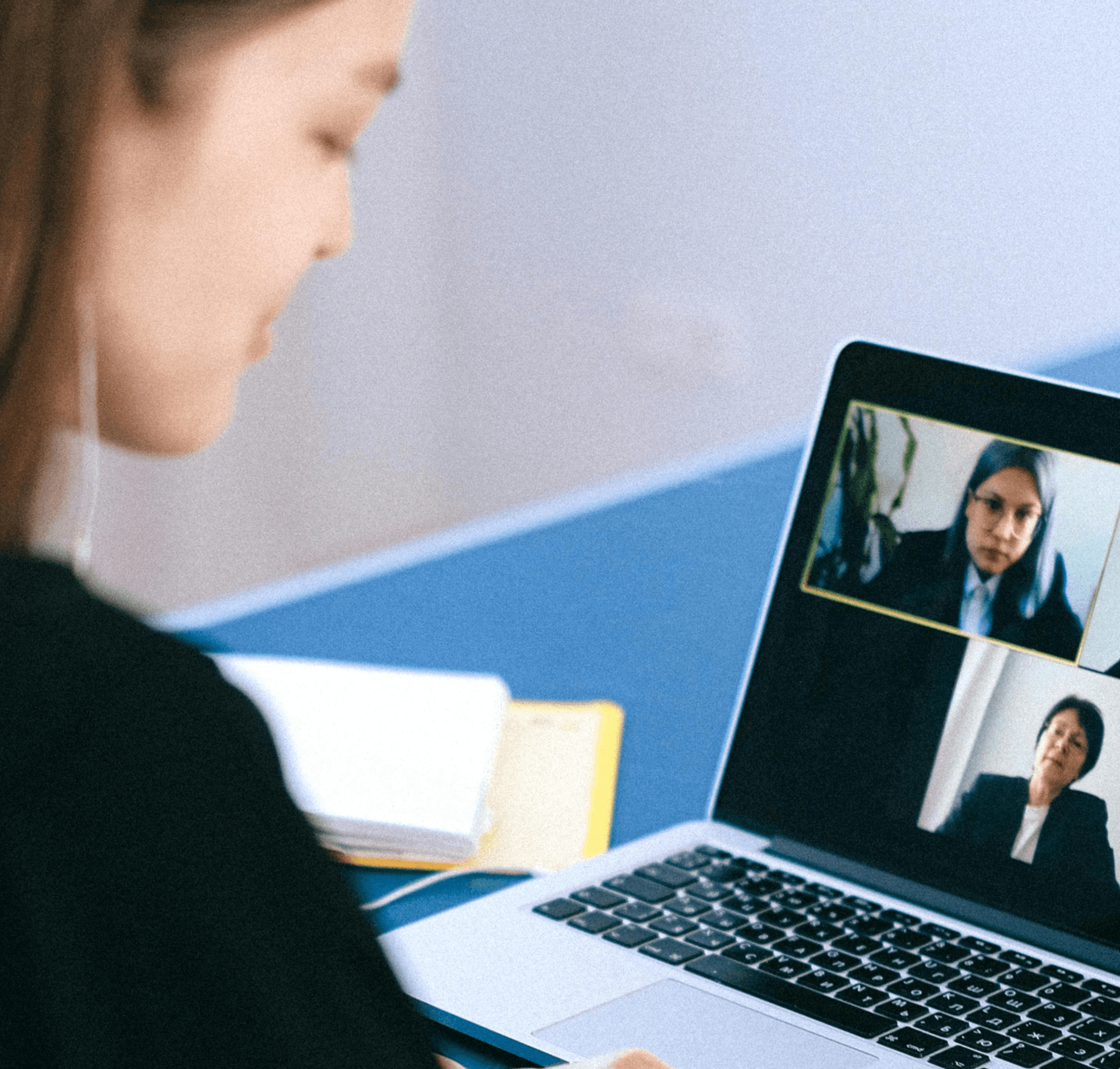Frau sitzt vor einem Computer und nimmt an einem Webinar teil.