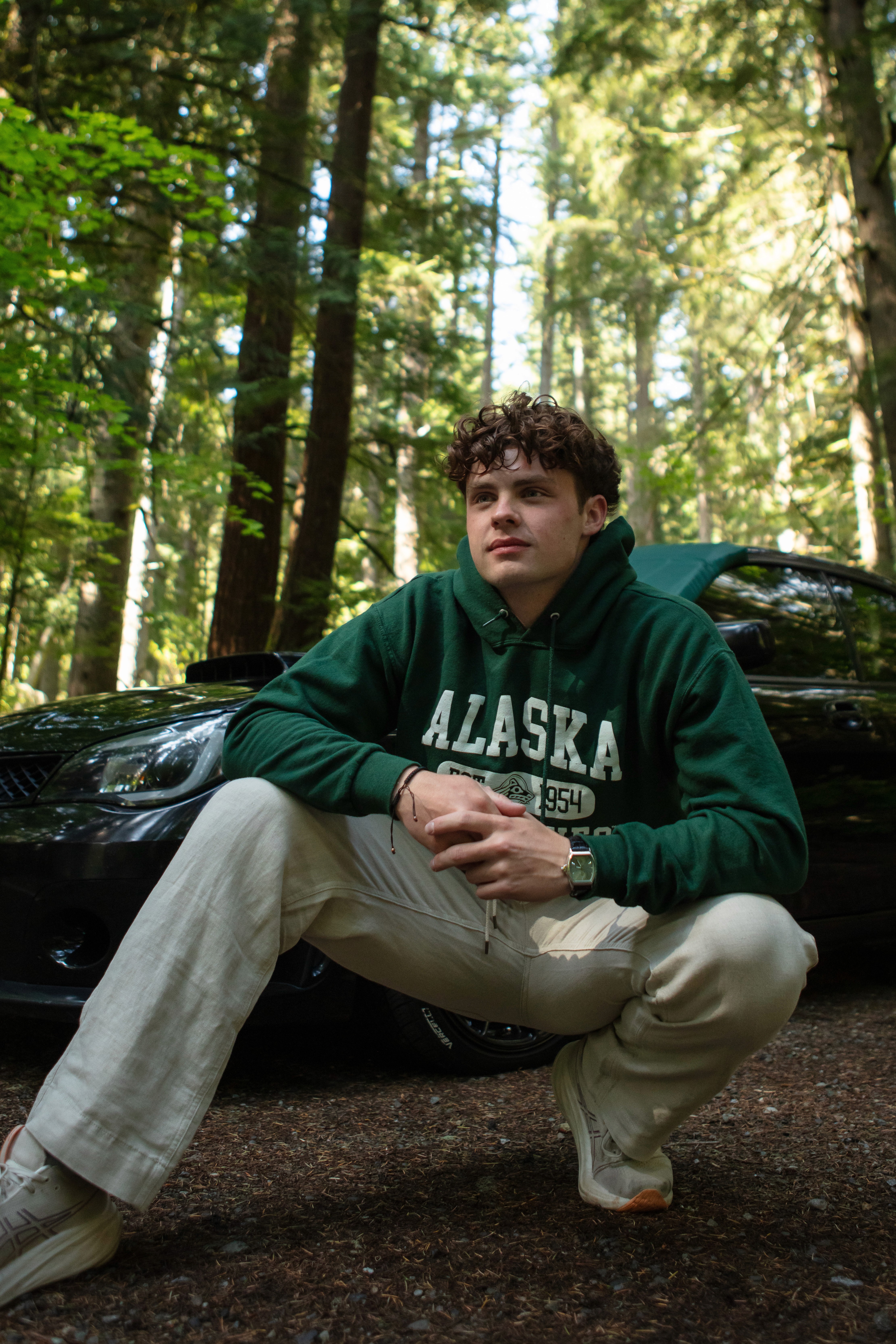 Modern home office setup with a monitor, ergonomic chair, keyboard, and indoor plants near a window with blinds.