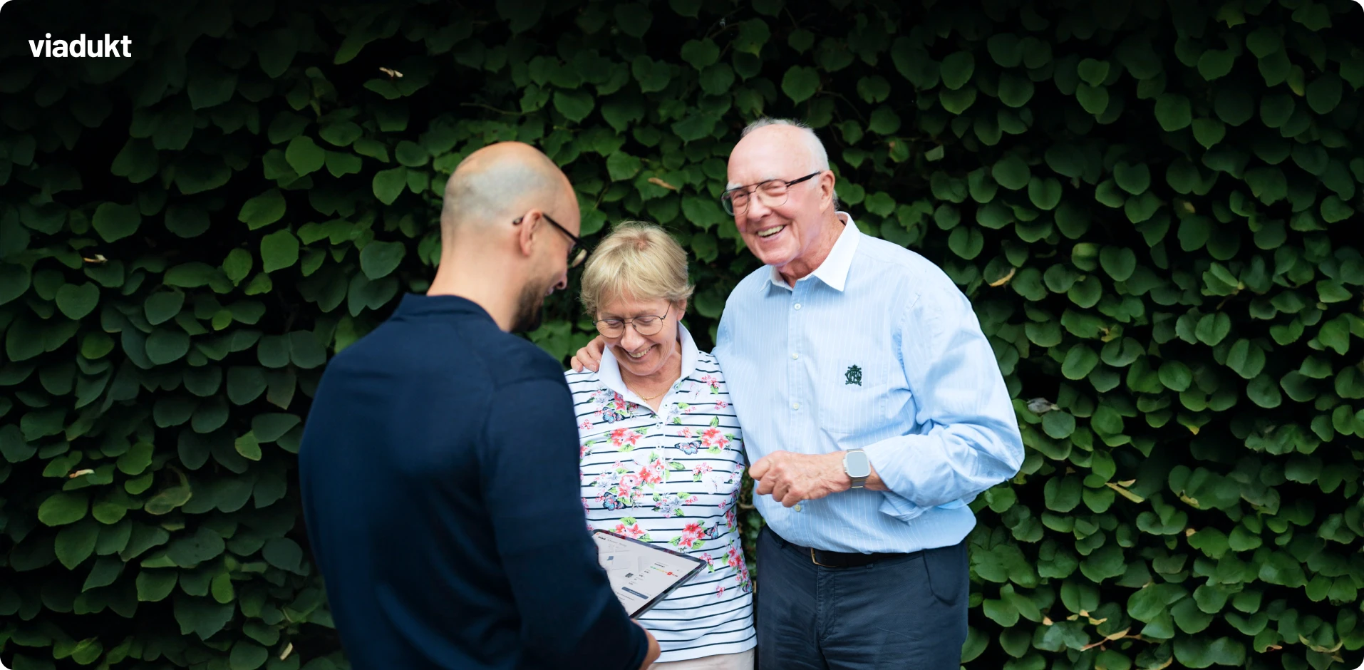 Energieberater Salihu im Beratungsgespräch zur energetischen Sanierung mit Frau und Herr Stein. In der Hand hält er ein Tablet mit der viadukt plattform die ihn bei der Beratung unterstützt