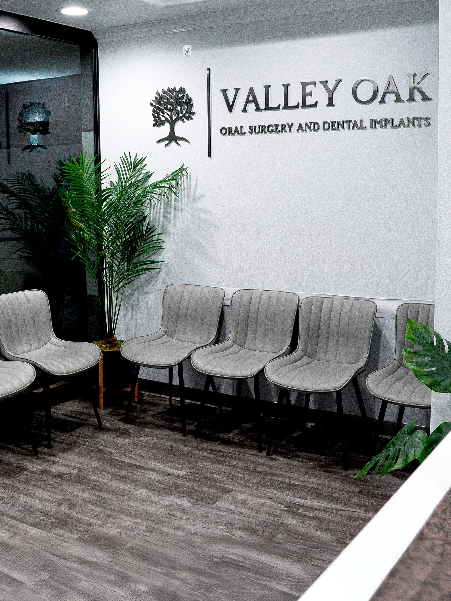 Modern oral surgery office waiting room with Valley Oak Oral Surgery and Dental Implants signage in Fresno, CA