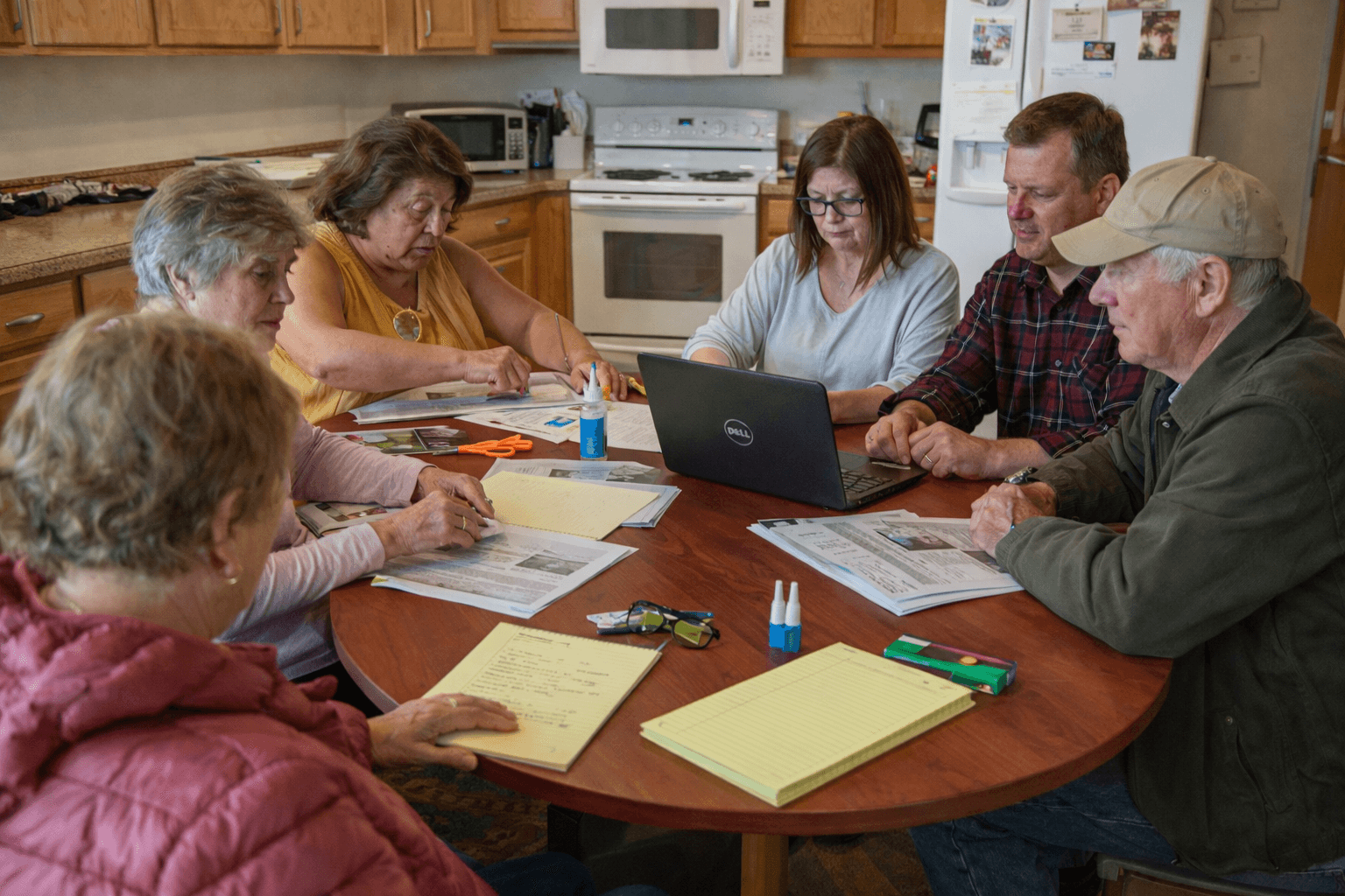 Conversion Truth for Families - Men and Women sitting around a wooden kitchen table with notebooks and a laptop