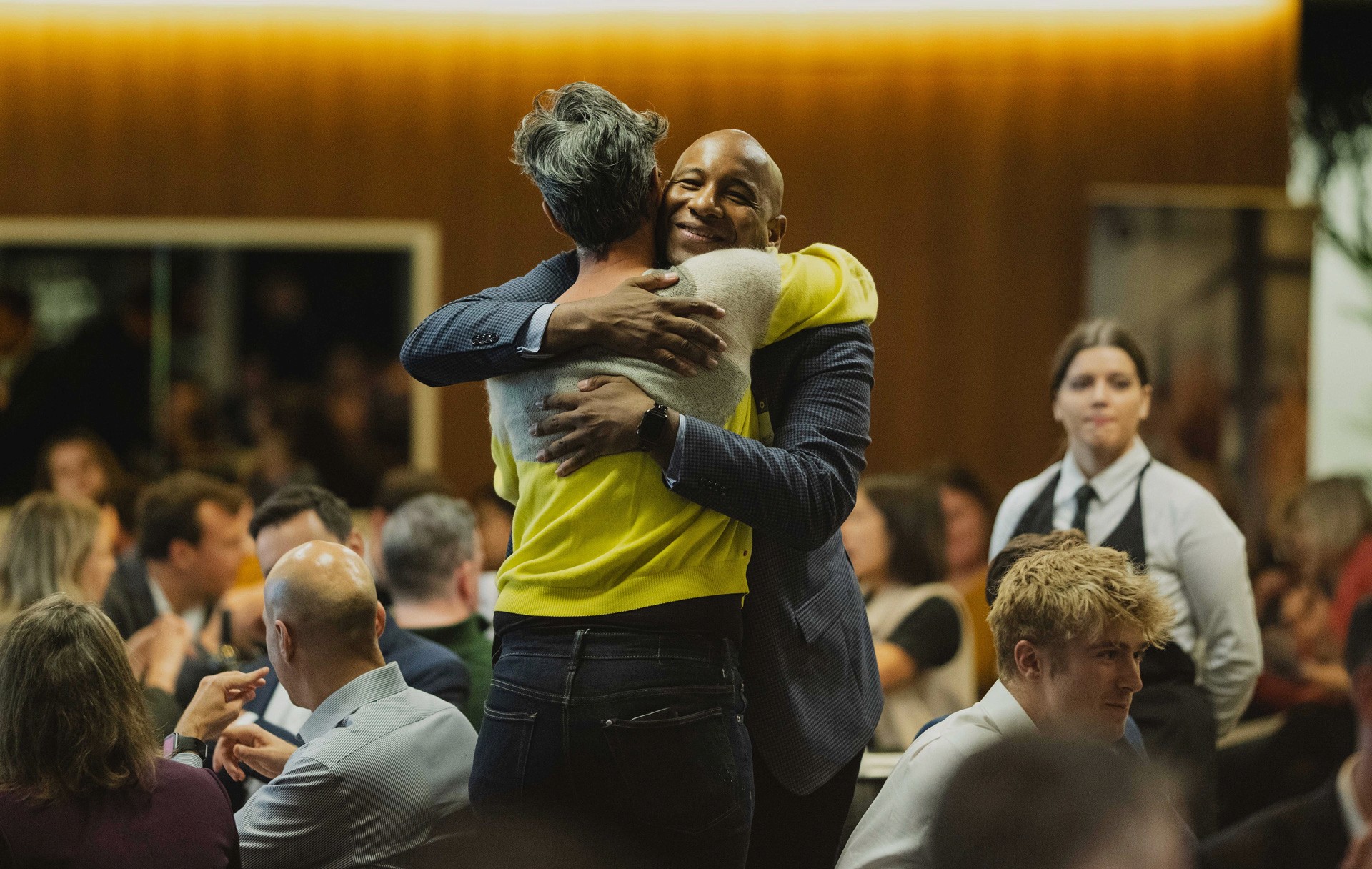 A silhouette of a person wearing sunglasses, with tousled hair, against a teal background.
