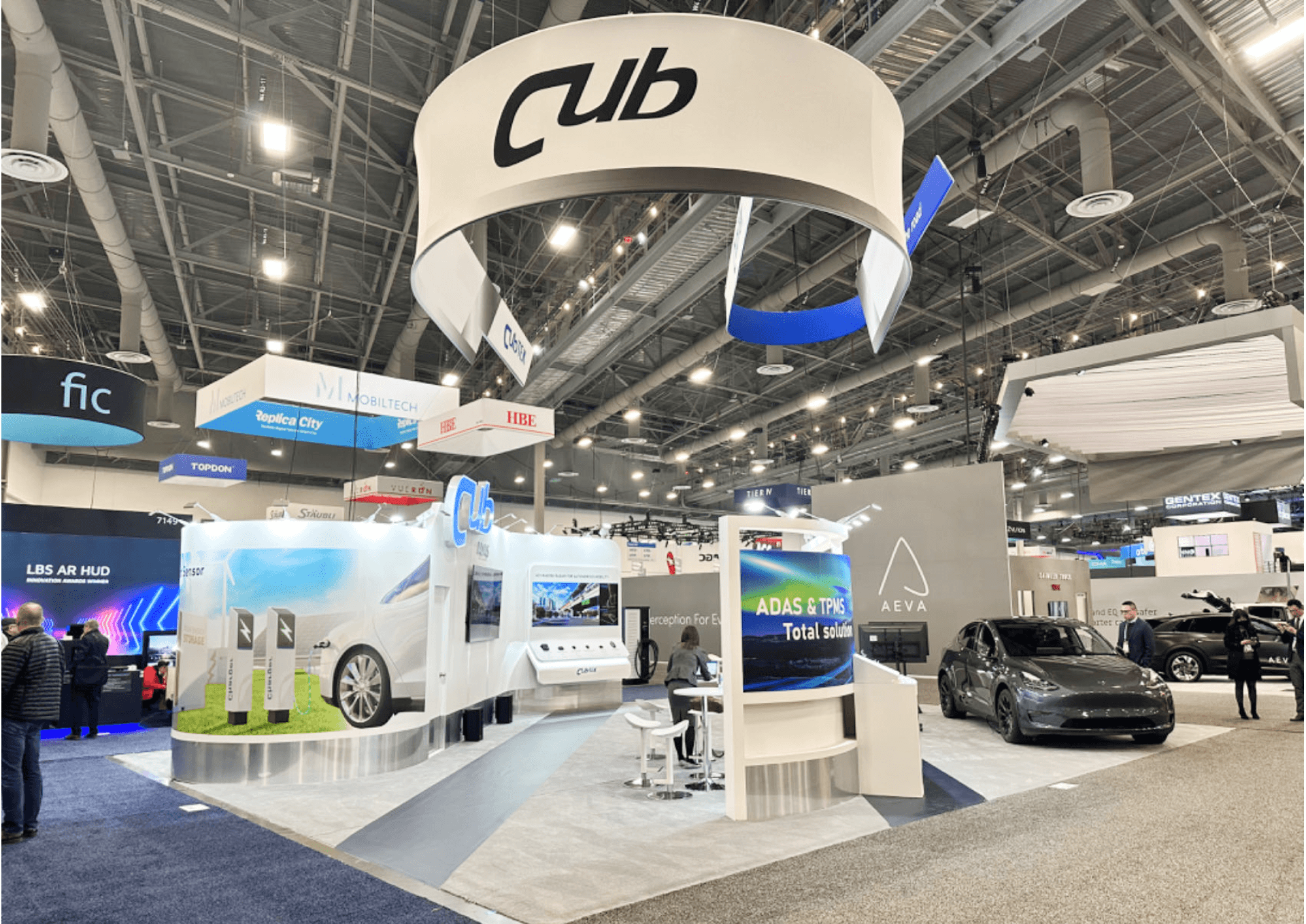 Massive double-helix style hanging banner structure floating above the CUB booth, displaying "Your best partner on the road".