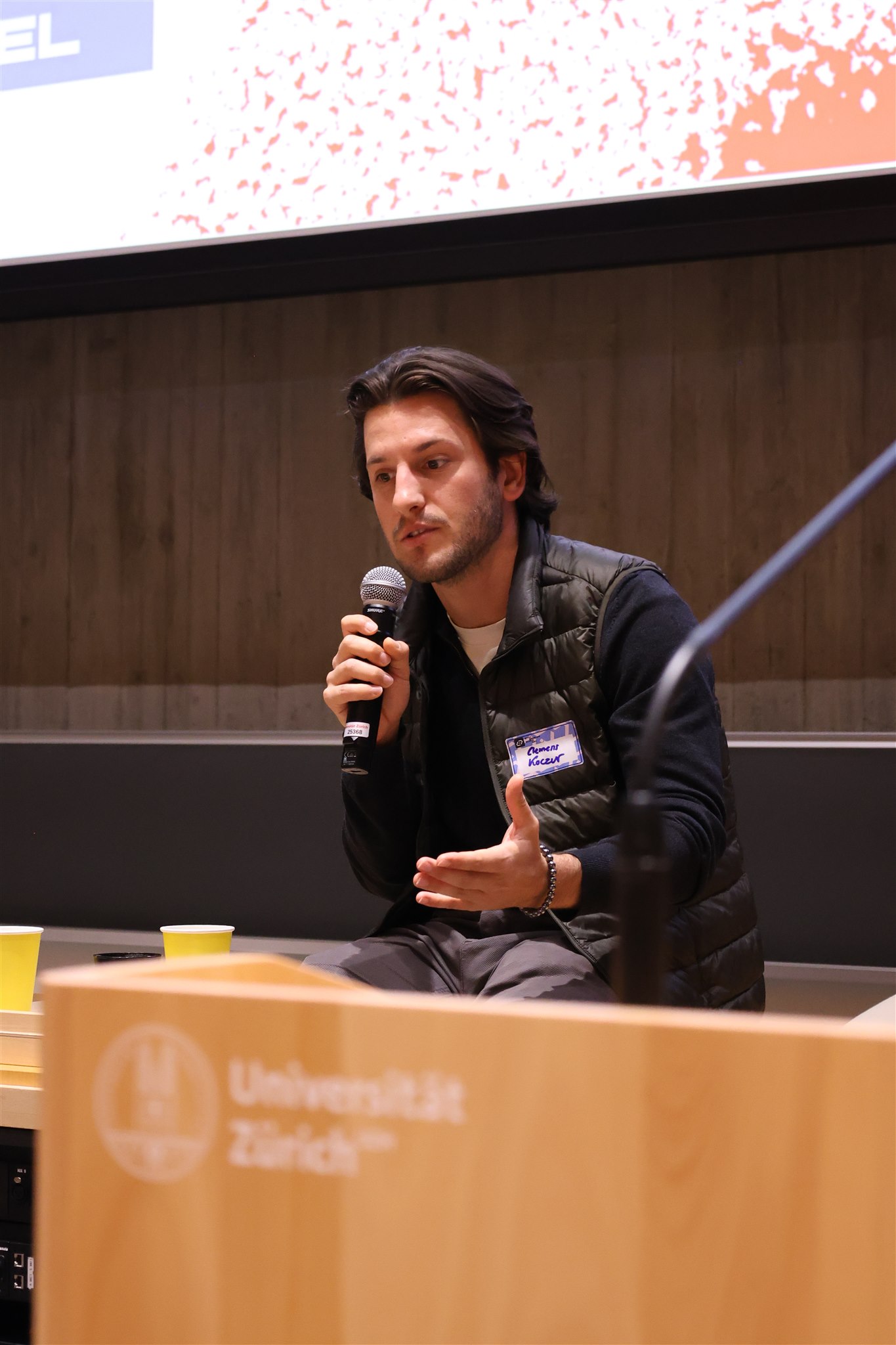 Tech speaker presenting ideas and gesturing during EthereumZüri conference