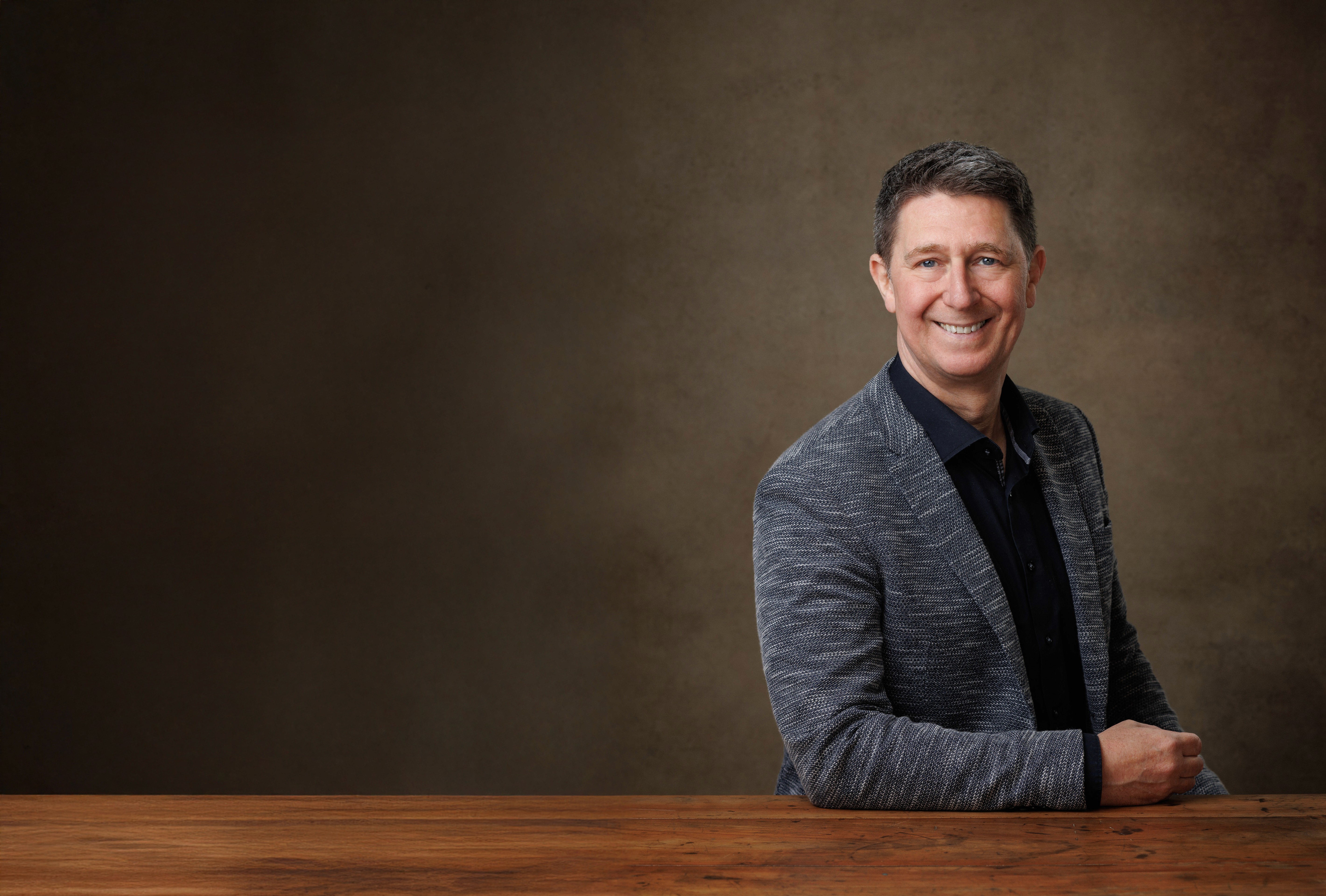 woman in blue tank top standing beside white wall