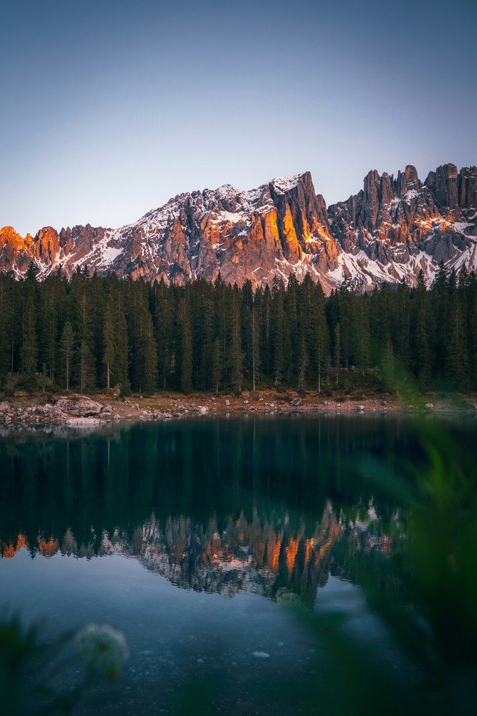 A lake surrounded by trees with a mountain in the distance