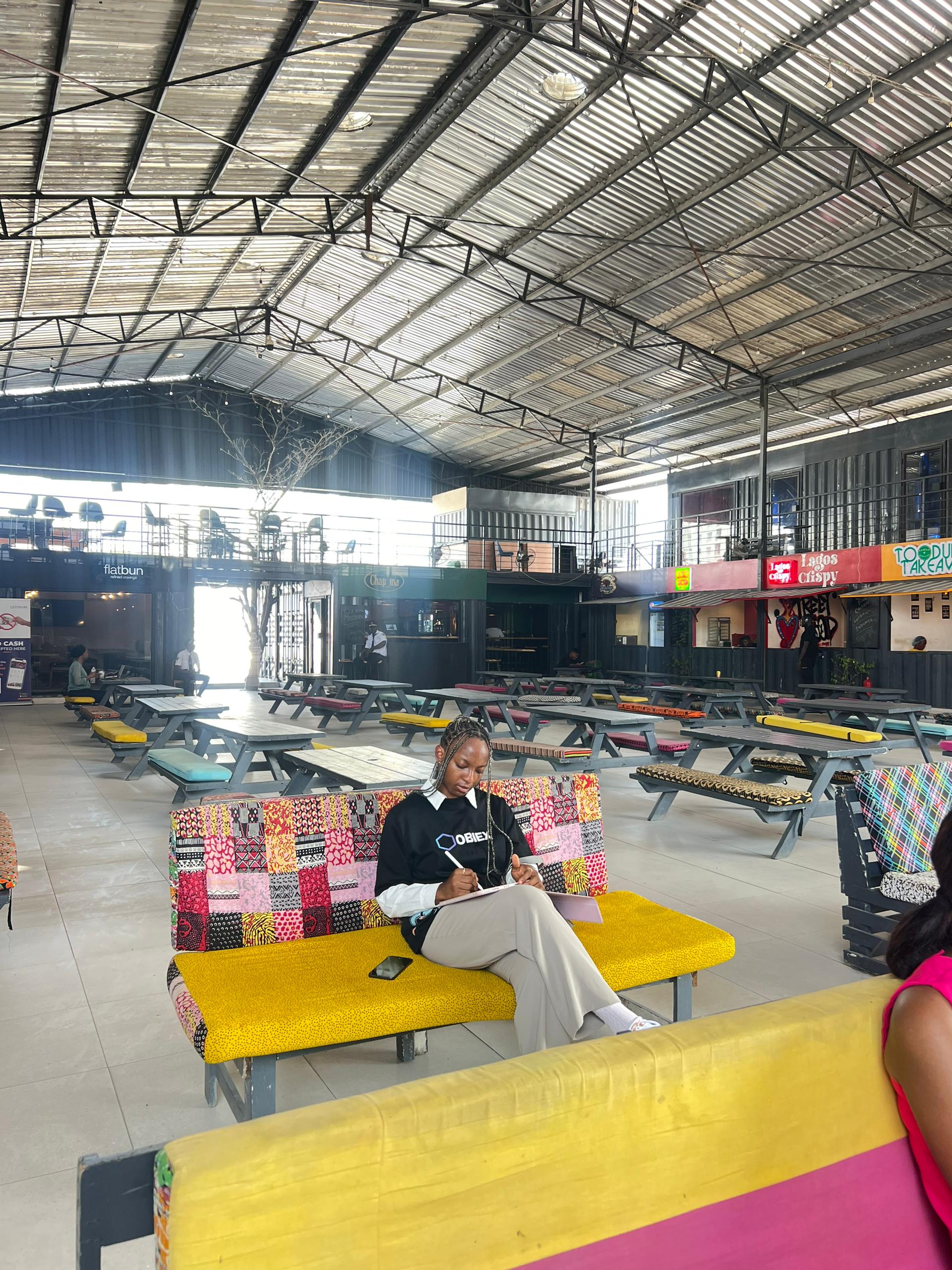 Person holding a book in a library with bookshelves in the background.