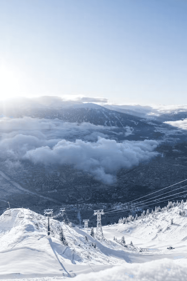 Modern indoor train station with a sleek monorail, escalators, and glass-enclosed elevator. Bright lighting from ceiling fixtures.