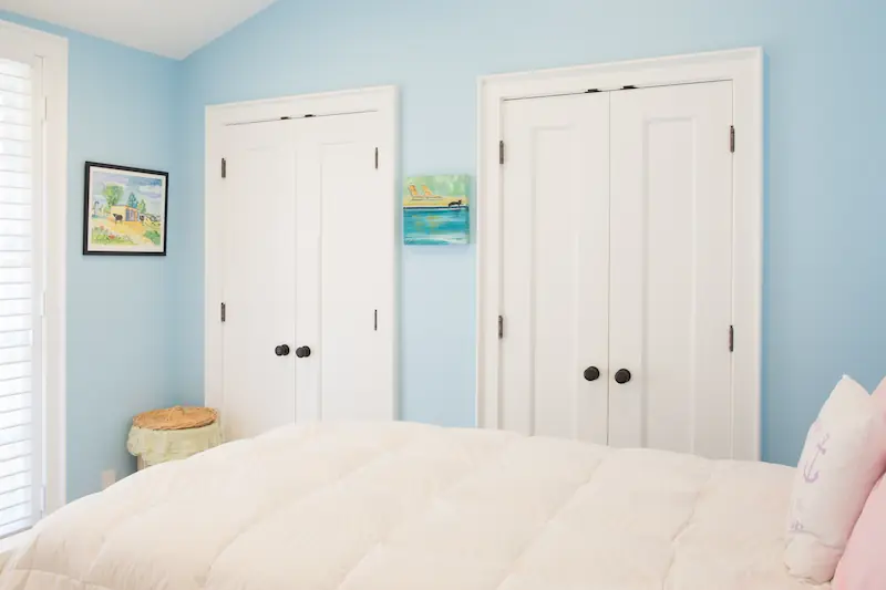 Two closet door sets with white doors in a guest bedroom from the Big Canyon Remodel project. Photo by Chris Darnall.
