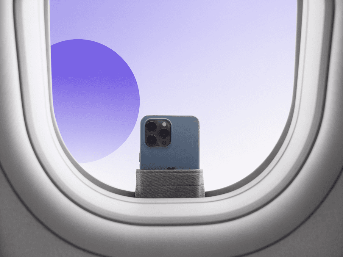 A single smartphone propped on an aeroplane window ledge, the only device you need to carry