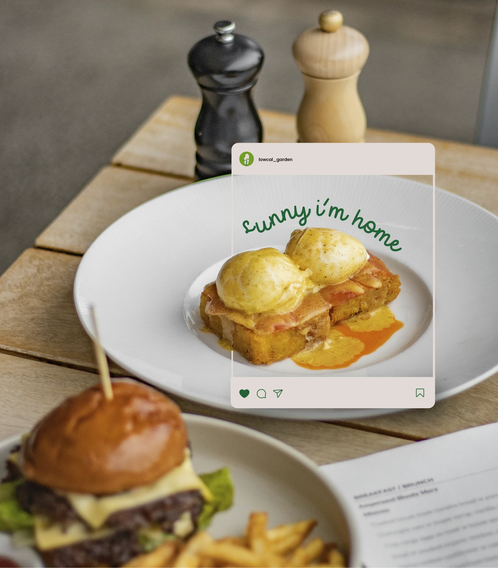 Lowcal Garden Instagram social media post mockup — 'Sunny I'm Home' eggs benedict brunch photography overlaid on restaurant table scene with burger and salt and pepper mills — social media content and food photography by Makers' Studio
