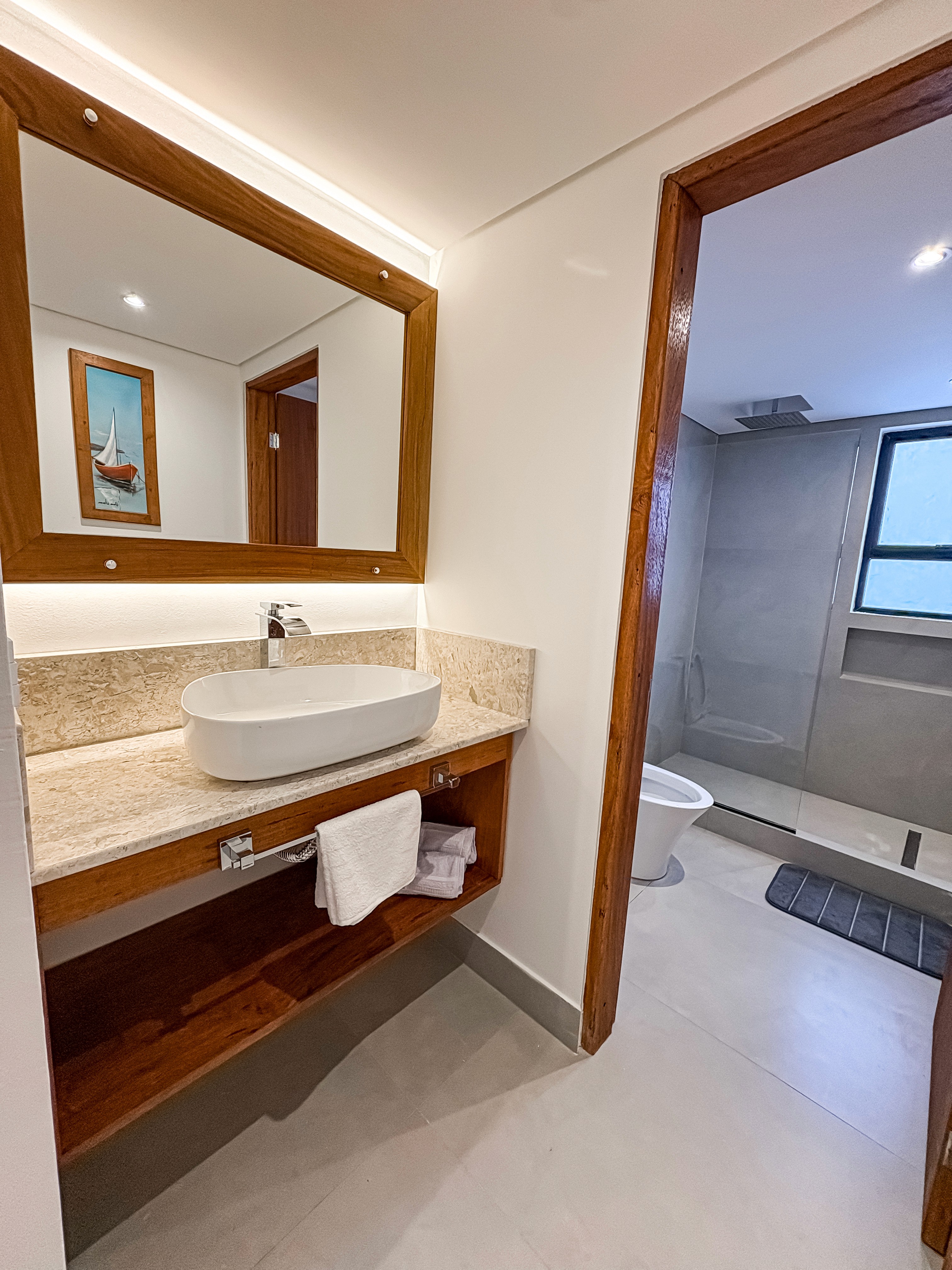 Loft bed close-up, cozy with layered pillows, sketchpad and headphones resting on the nightstand.