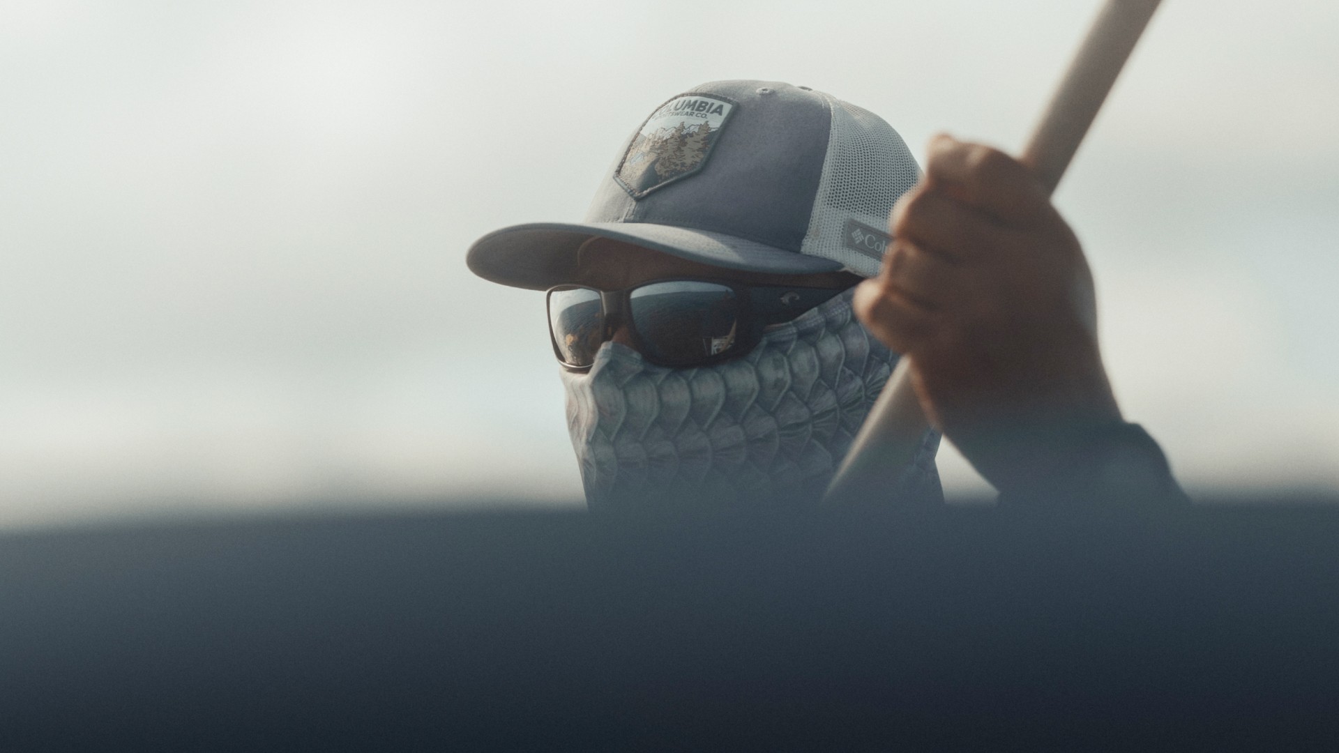 Portrait of Fly Fishing Guide Marlon Leslie while he is poling the boat. The flats are reflecting in his sunglasses.