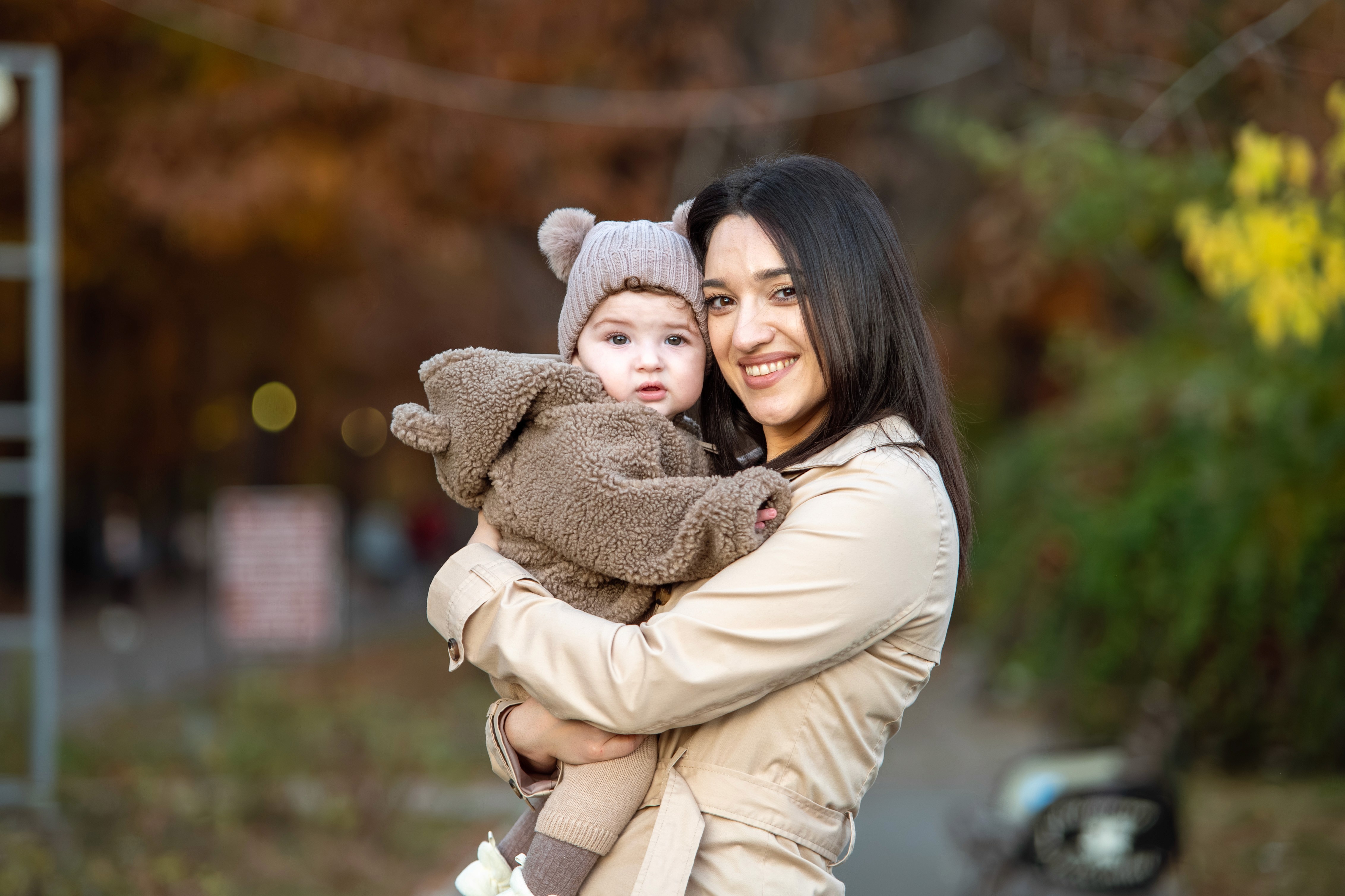 Ședință foto de familie în București, mamă cu copil în brațe, cadru natural de toamnă.