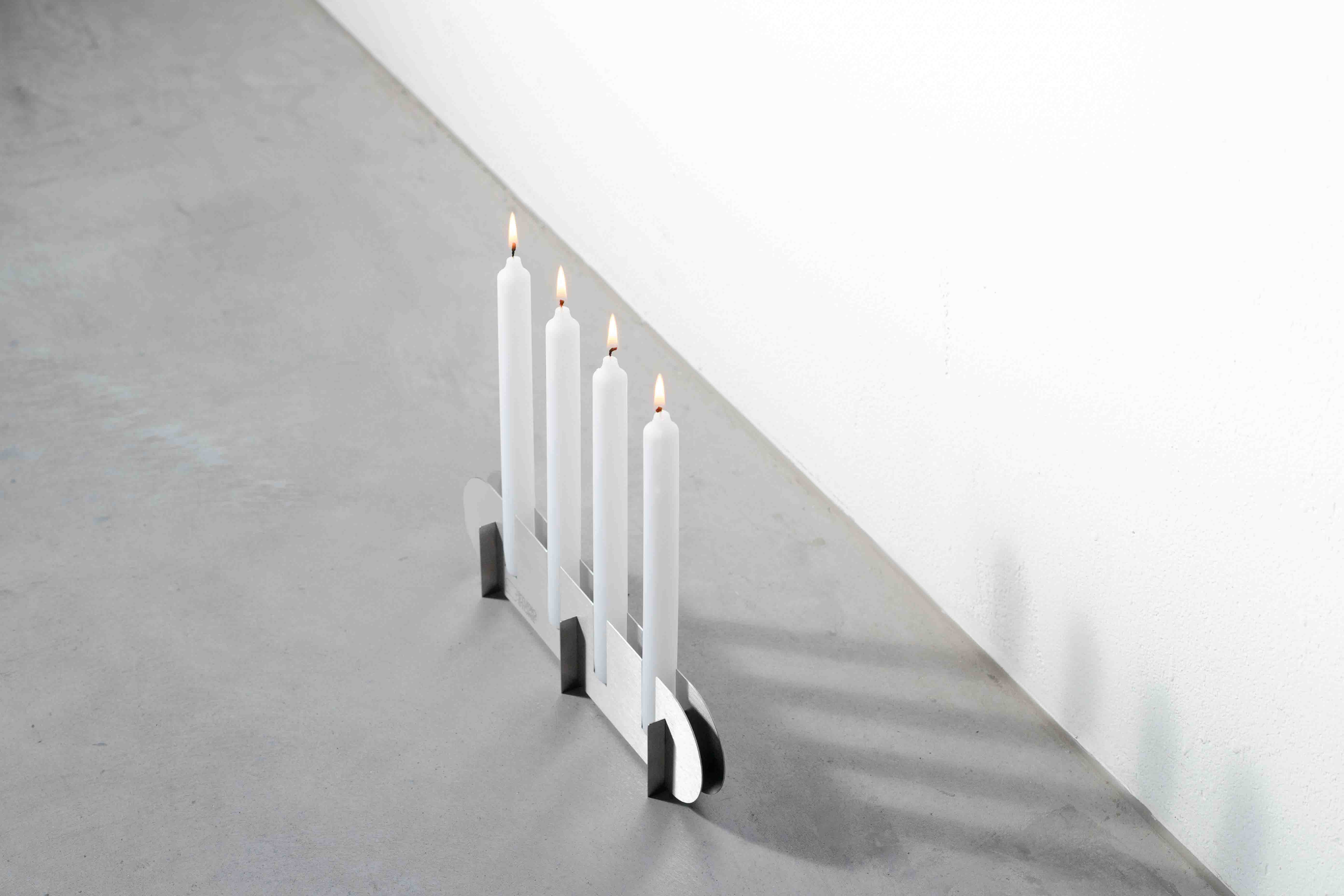a metal candle holder with lit candles on a concrete floor