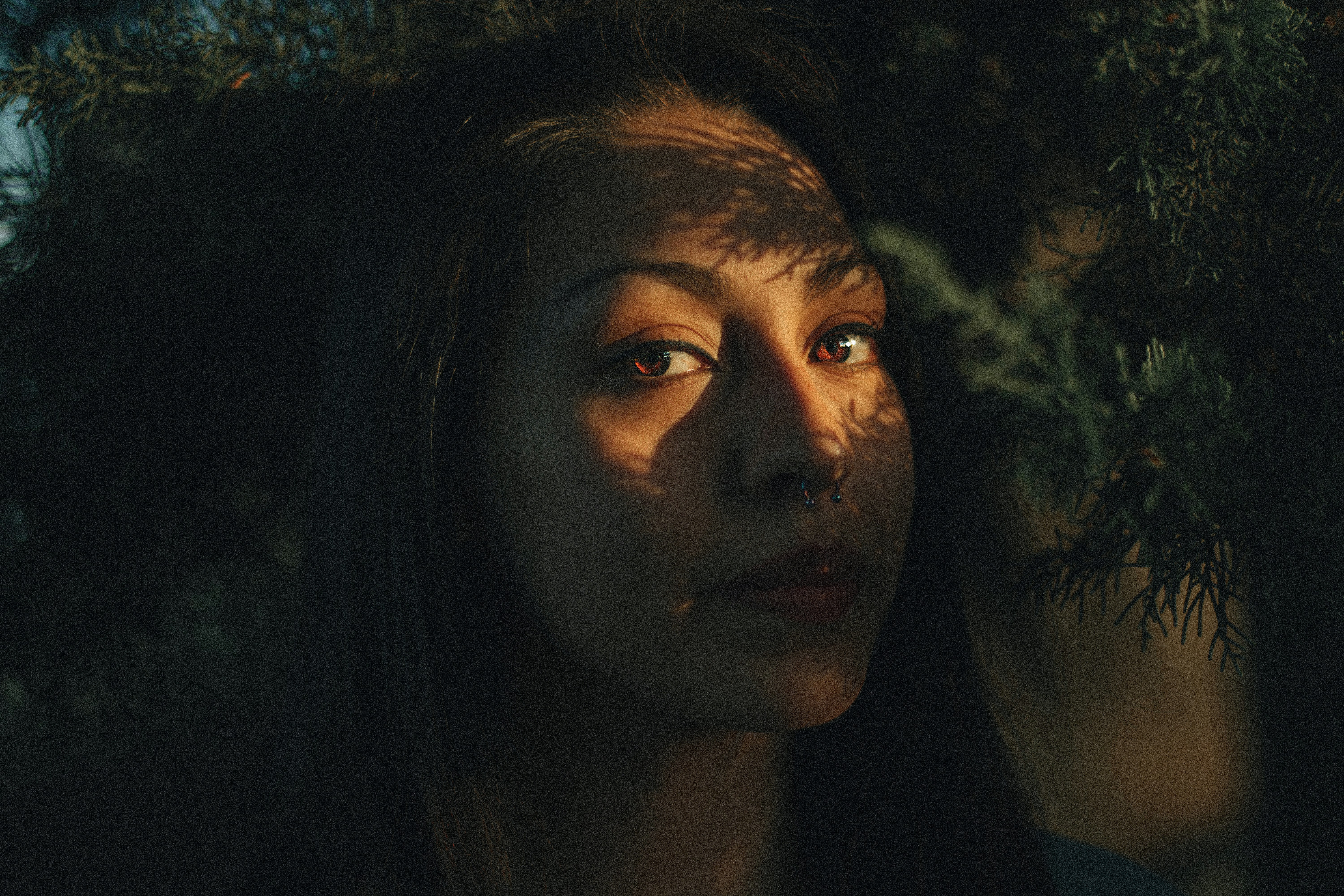 woman under leaves - What Colors Look Best on Brown Skin