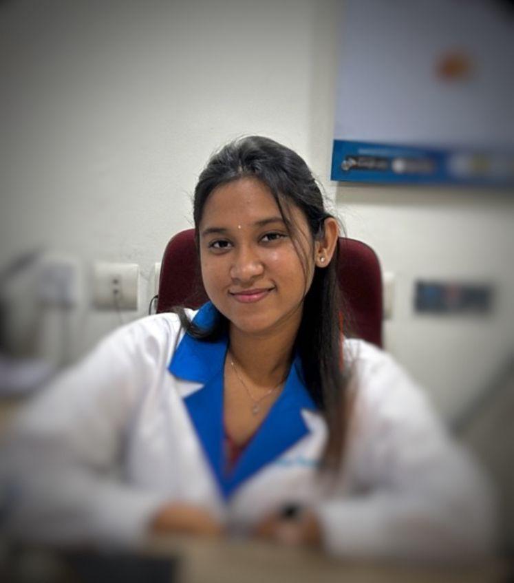A businesswoman sitting at her desk, smiling and looking at the camera.
