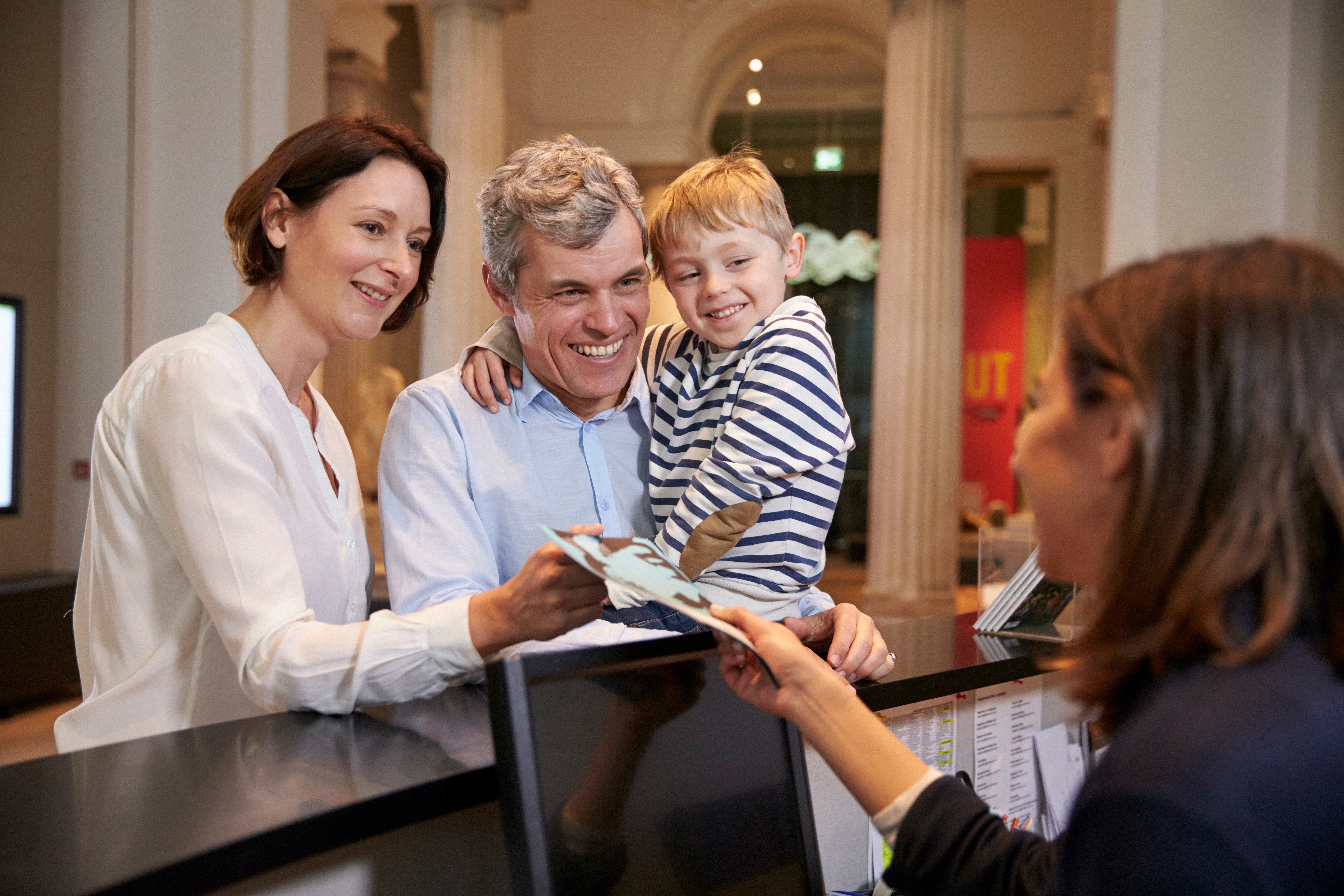 Front of house staff providing tickets to a family at the museum.