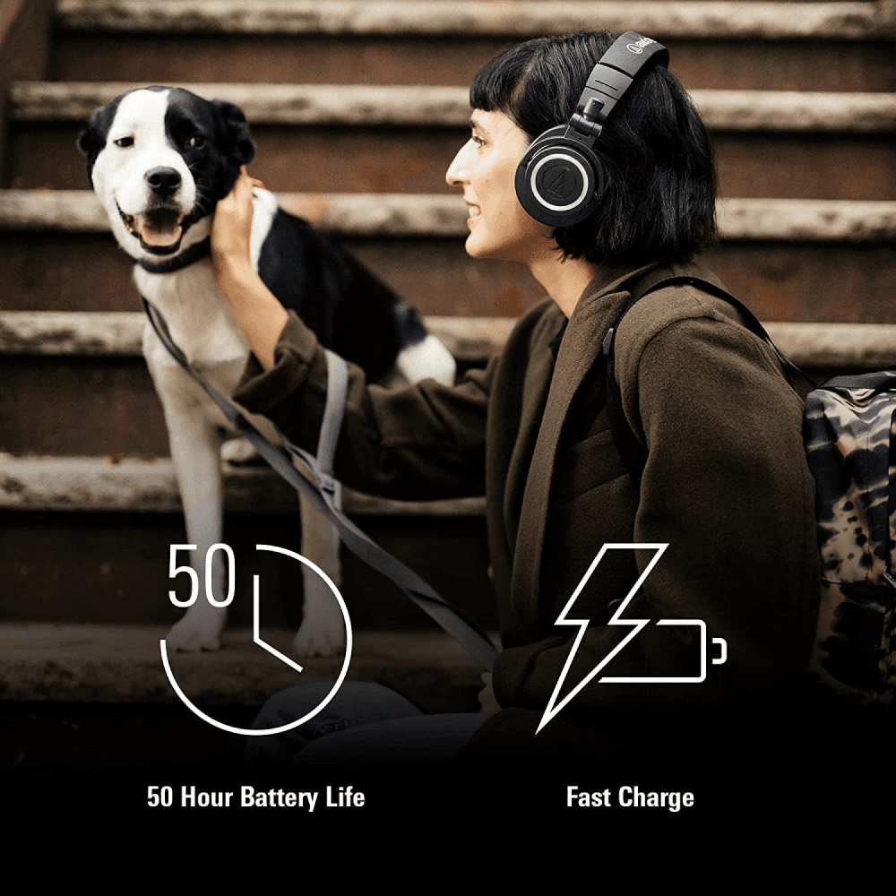 Woman with Audio-Technica ATH-M50xBT Bluetooth headphones, petting her dog. Highlights include 50-hour battery life and fast charging.