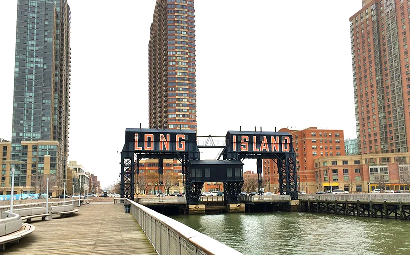 Tall modern skyscraper with vertical lines, viewed against a clear blue sky.