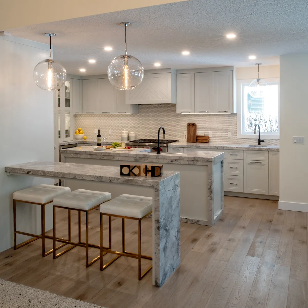 Image of Luxury kitchen design with marble island, white cabinets, and modern fixtures by KHD Homes.