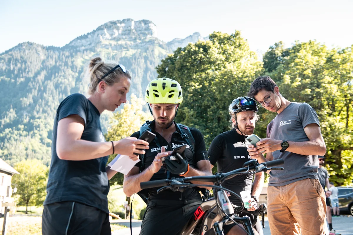 Team Snowleader analysing the trail on smartphones before the event.