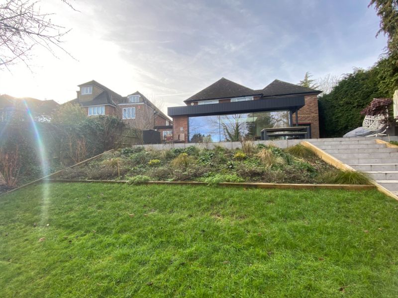 Modern porcelain tiered garden steps and sloped lawn installation in High Wycombe."