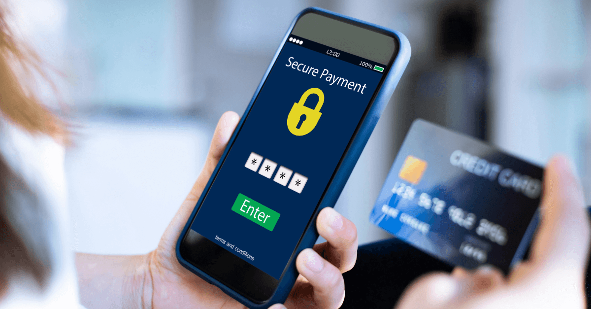 A closeup of a person’s hands. One holds a credit card and the other holds a cell phone with a secure payment screen displayed.