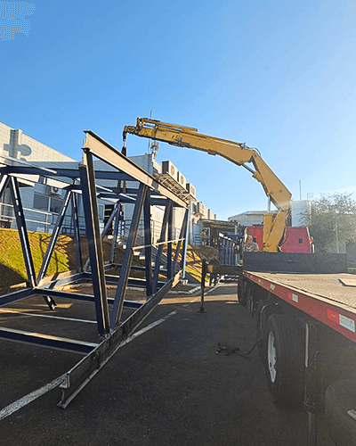 yellow excavator beside brown brick wall