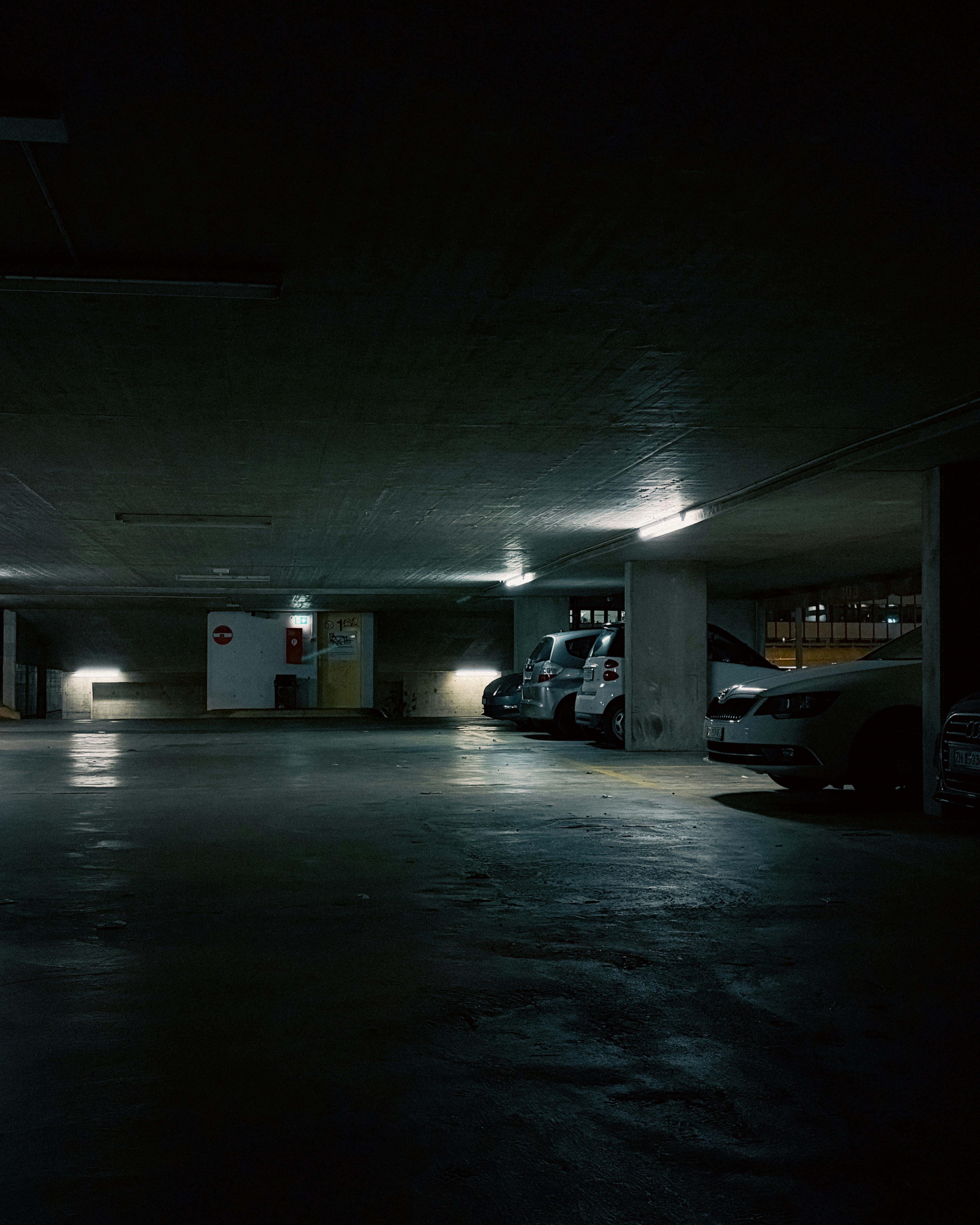 Cars parked in a dimly lit underground garage.