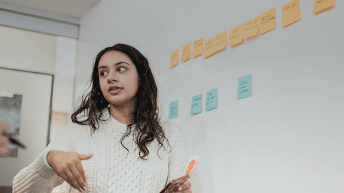 Close-up of a dark green leaf showing its textured surface and central vein against a muted background.