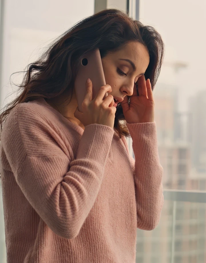 Woman looking overwhelmed by smartphone notifications.