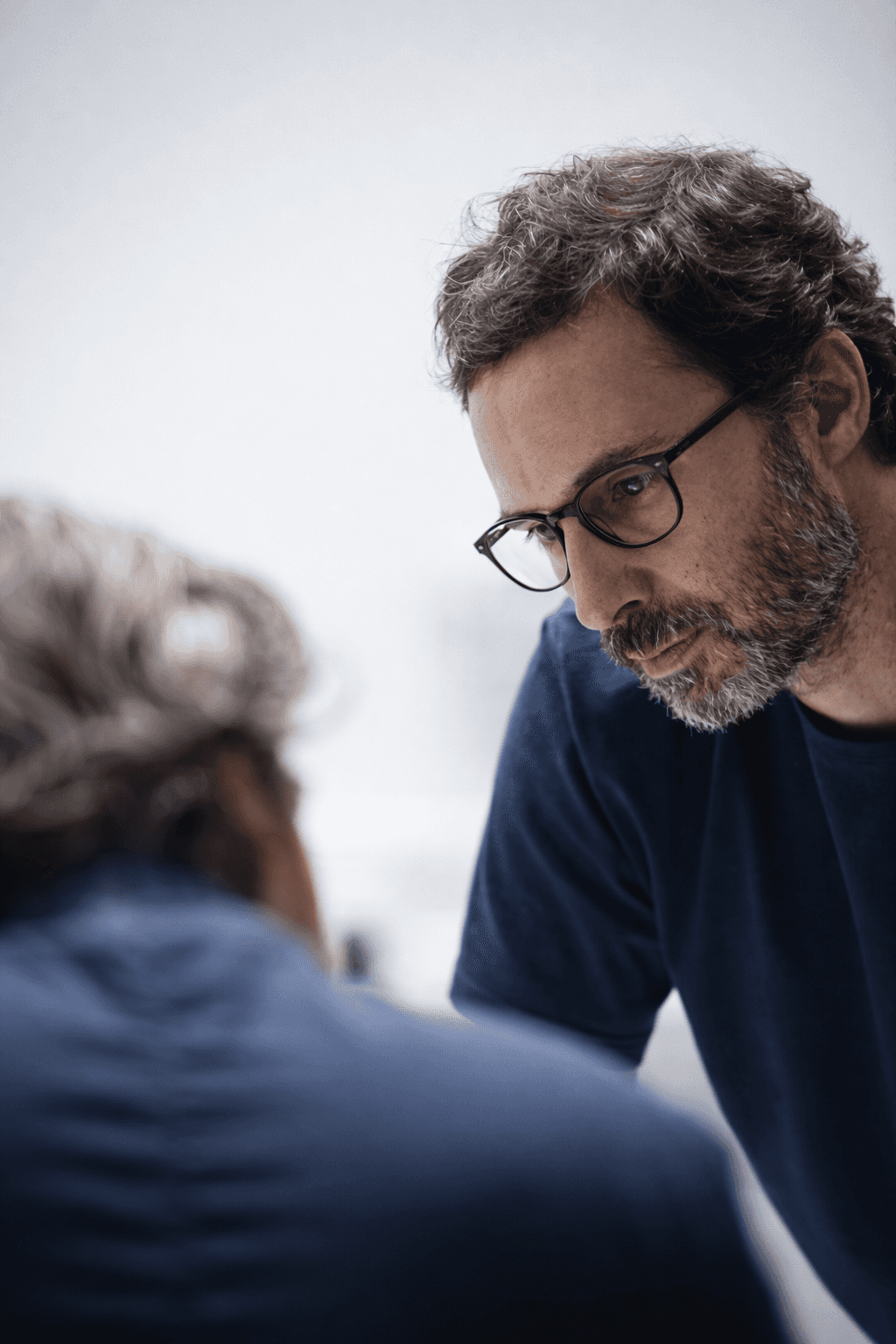 woman holding a phone and man looking at the phone. both are smiling