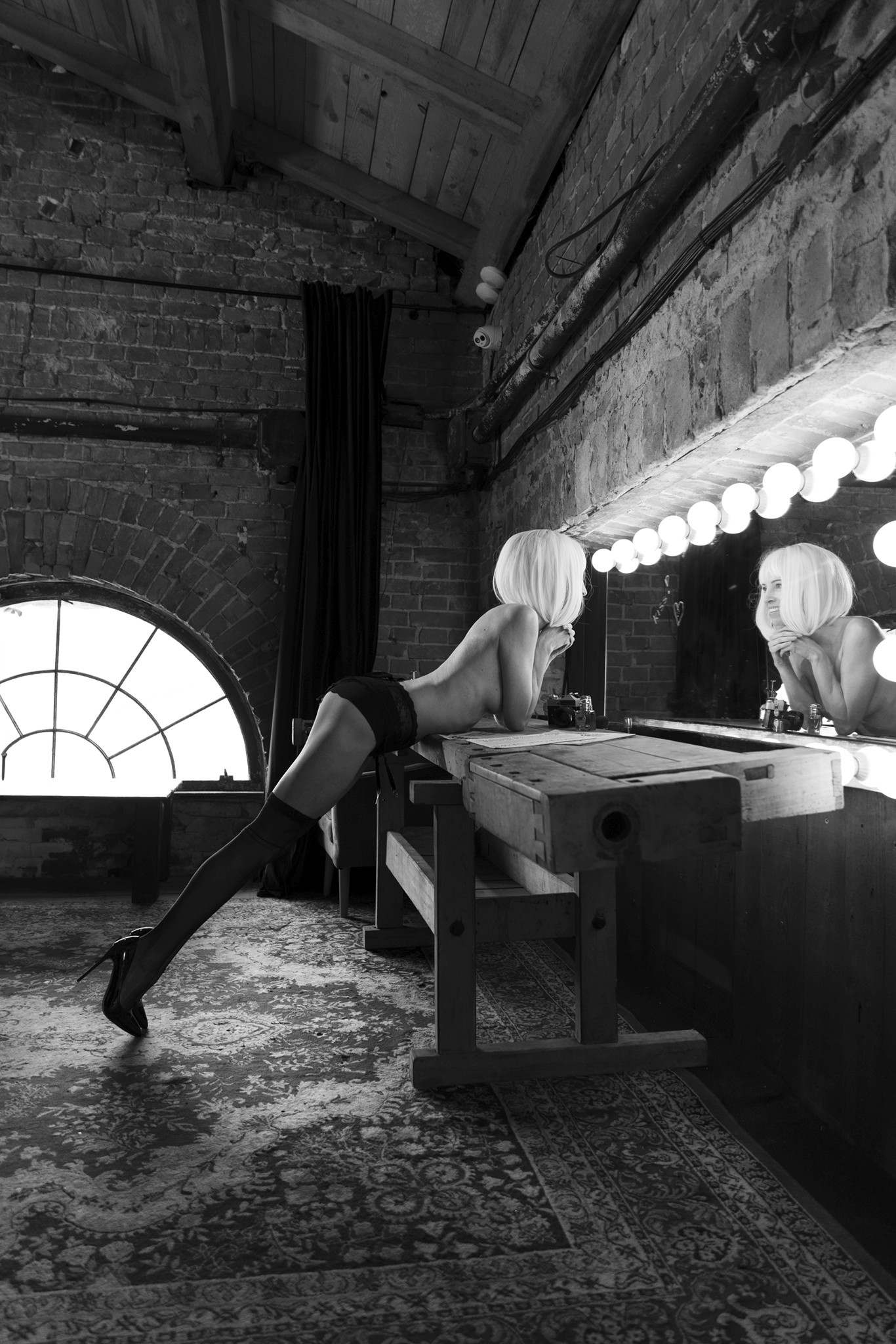 Woman standing on the floor by a dressing table, black and white - The Space Between Roles - Agnieszka Czyzkowska Photography