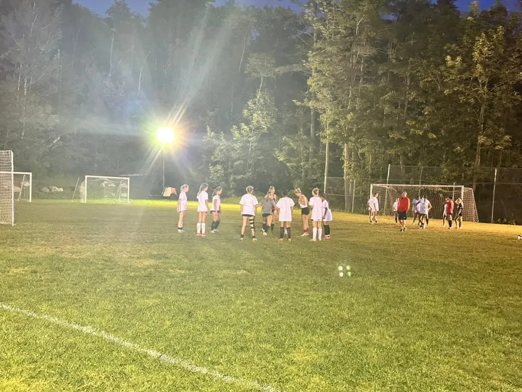 Night soccer game under the field lights at Camp Lenox