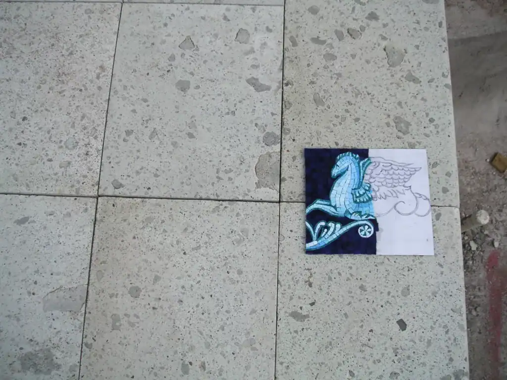 Hand-painted tile art featuring a blue winged horse on a dark background.