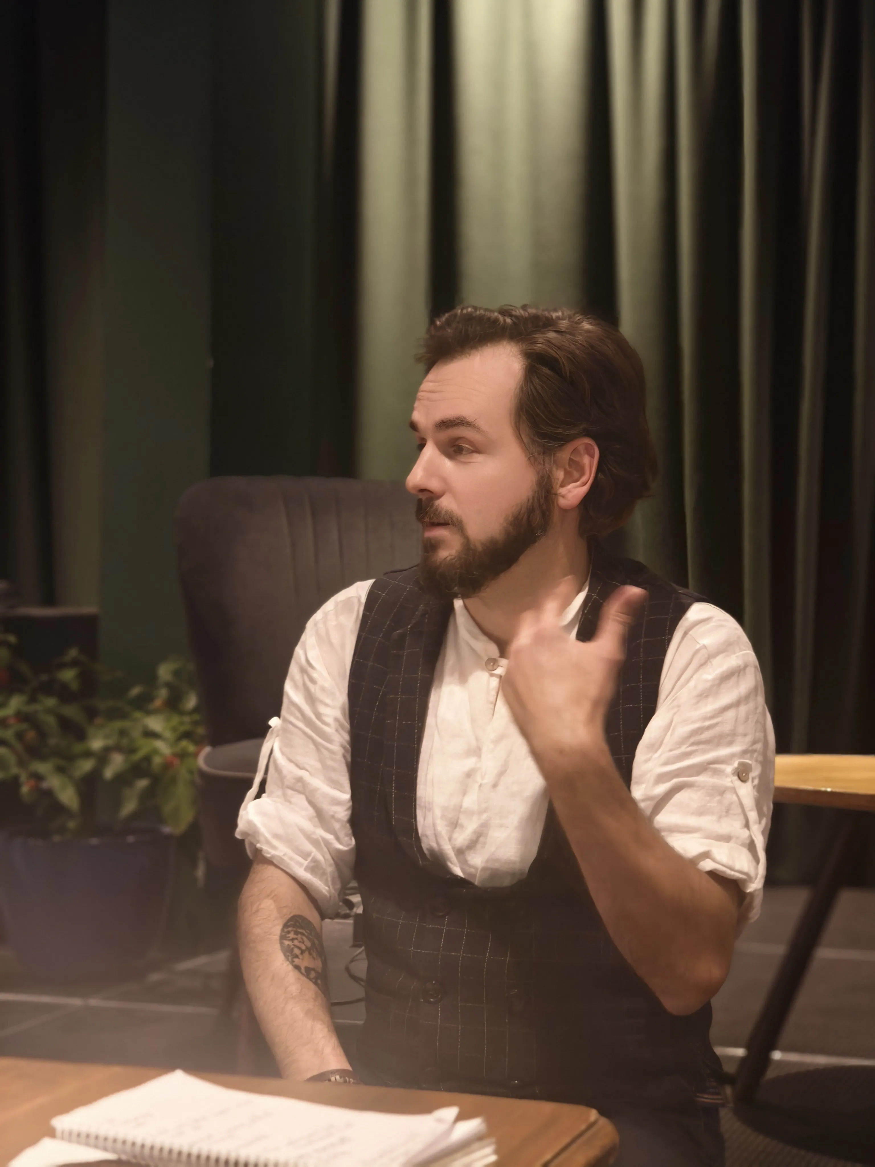 A person sitting down and talking under a spotlight
