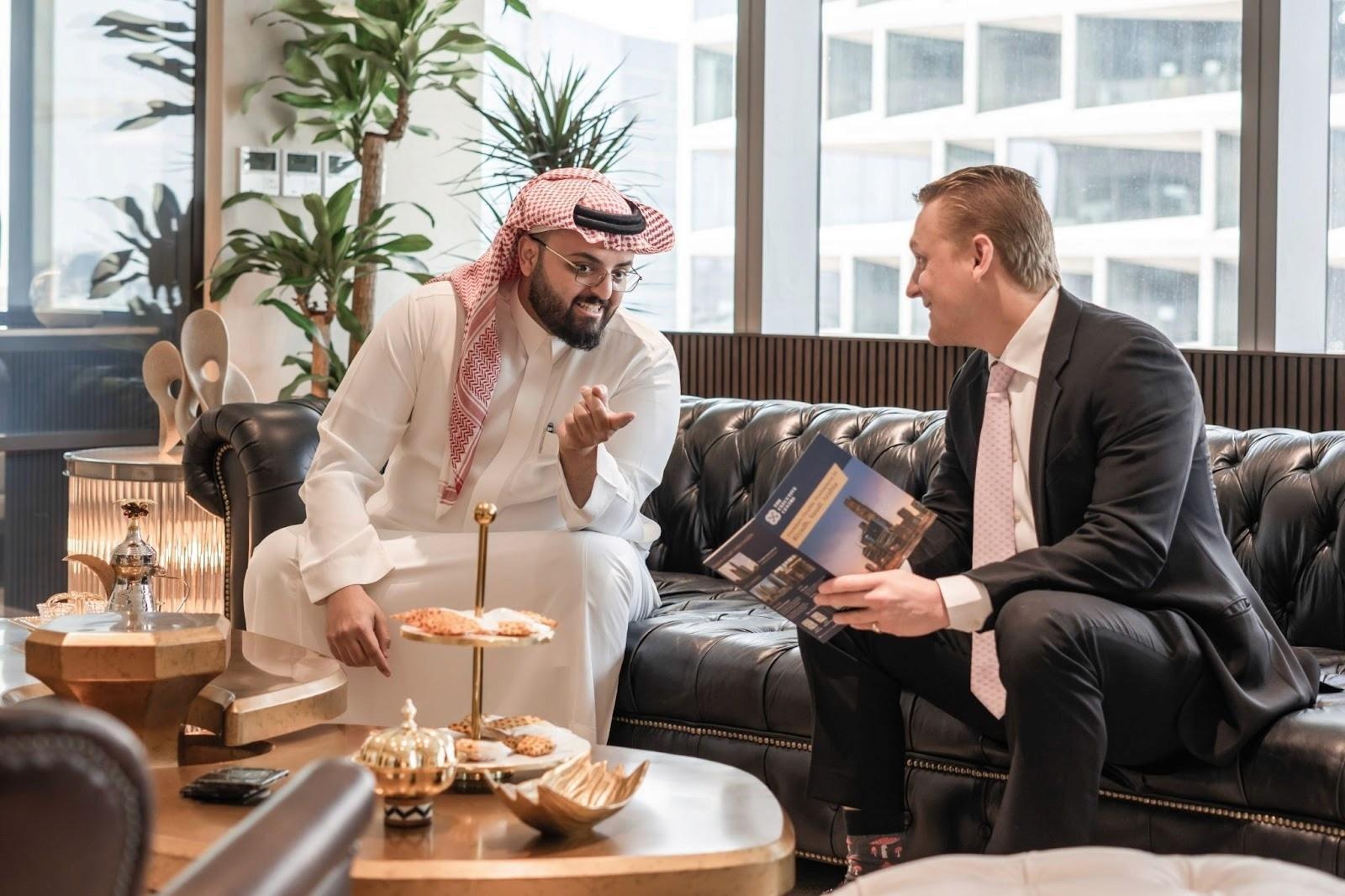 رجلا أعمال يتحدثان عن خطوات تأسيس شركة ذات مسؤولية محدودة في السعودية.