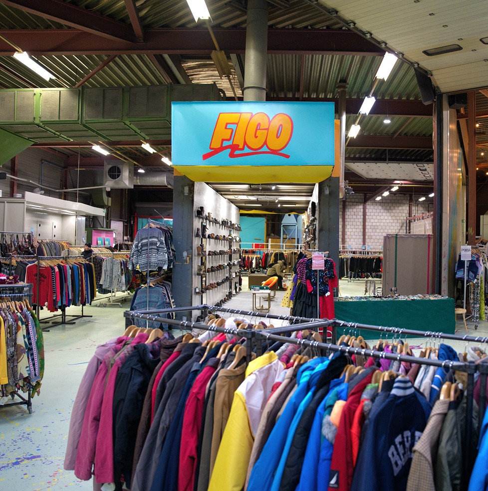 Indoor thrift store with clothing racks,  "FIGO" sign
